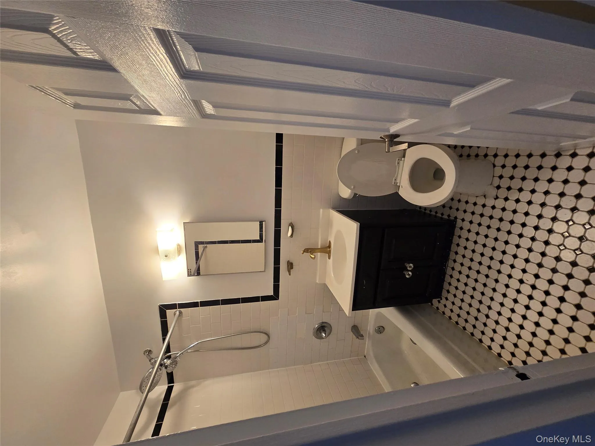 Full bath featuring tile walls, vanity, a wainscoted wall, and shower / bath combination Full bath featuring tile walls, vanity, a wainscoted wall, and shower / bath combination