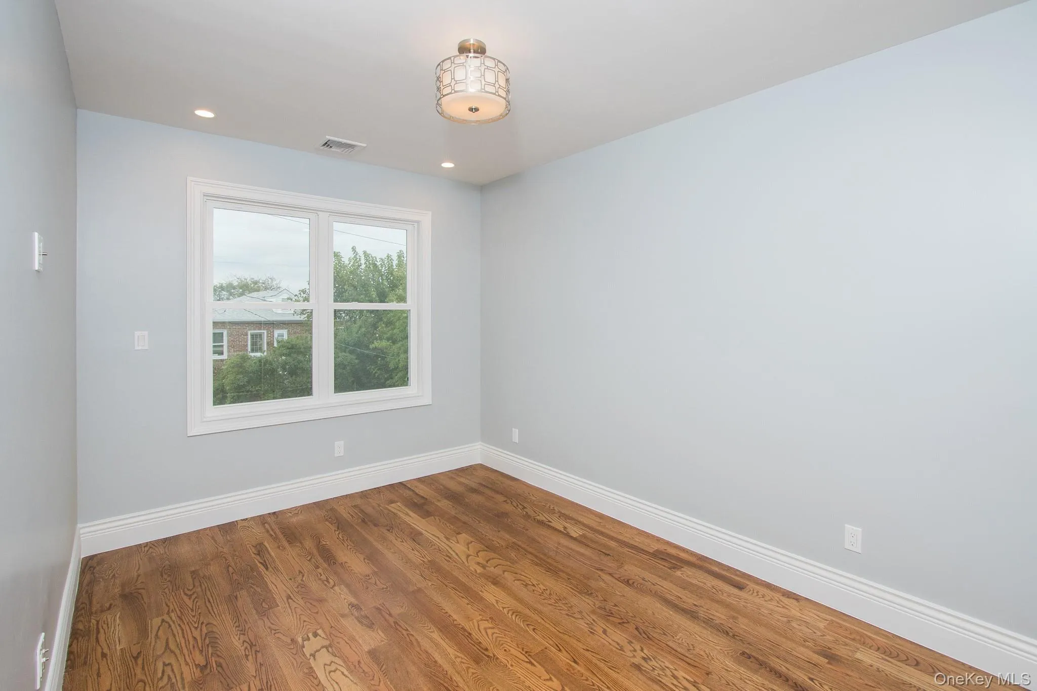 Empty room featuring wood finished floors and recessed lighting Empty room featuring wood finished floors and recessed lighting