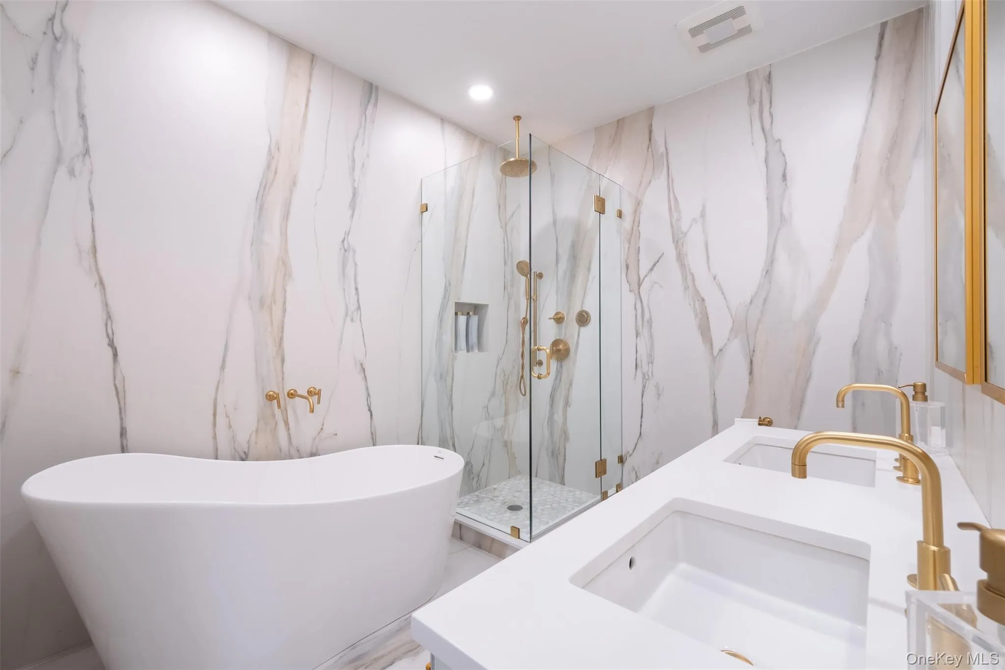 Full bath with stone wall, double vanity, a marble finish shower, a soaking tub, and recessed lighting Full bath with stone wall, double vanity, a marble finish shower, a soaking tub, and recessed lighting