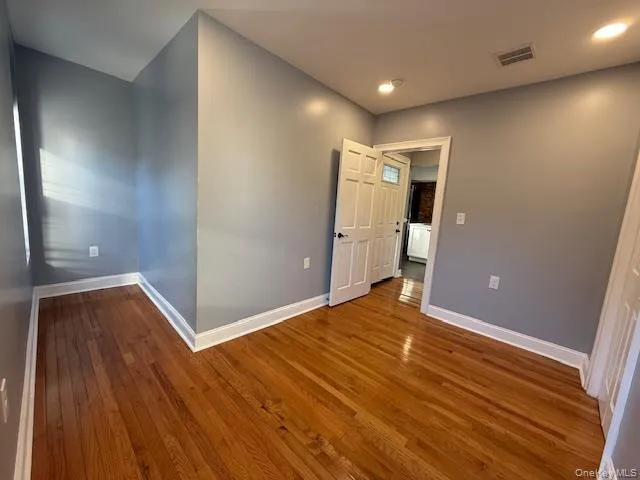 Empty room with hardwood / wood-style flooring and recessed lighting Empty room with hardwood / wood-style flooring and recessed lighting