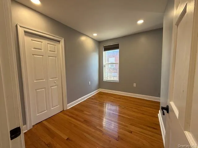 Unfurnished bedroom with wood-type flooring, recessed lighting, and a closet Unfurnished bedroom with wood-type flooring, recessed lighting, and a closet