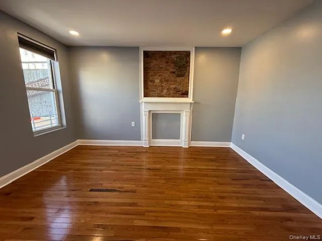 Unfurnished living room with dark wood-style floors and recessed lighting Unfurnished living room with dark wood-style floors and recessed lighting