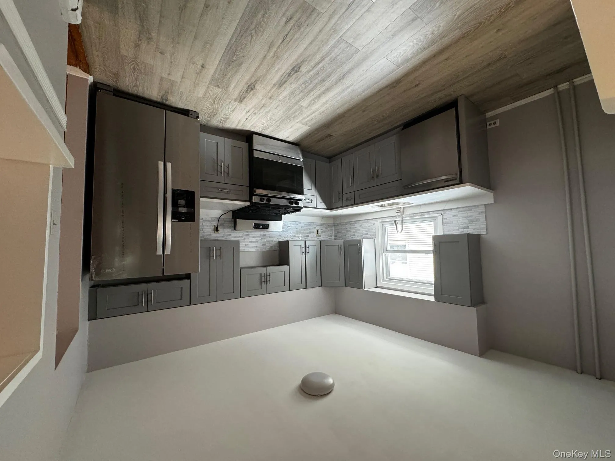 Kitchen with gray cabinetry, refrigerator, stove, dishwasher, and light wood-type flooring Kitchen with gray cabinetry, refrigerator, stove, dishwasher, and light wood-type flooring