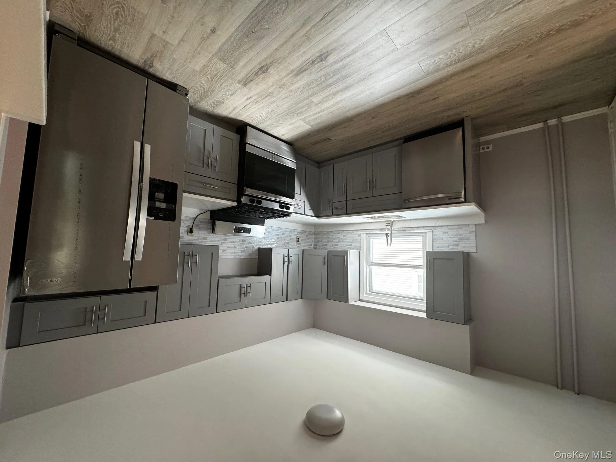 Kitchen featuring fridge, range, gray cabinets, and dishwashing machine Kitchen featuring fridge, range, gray cabinets, and dishwashing machine