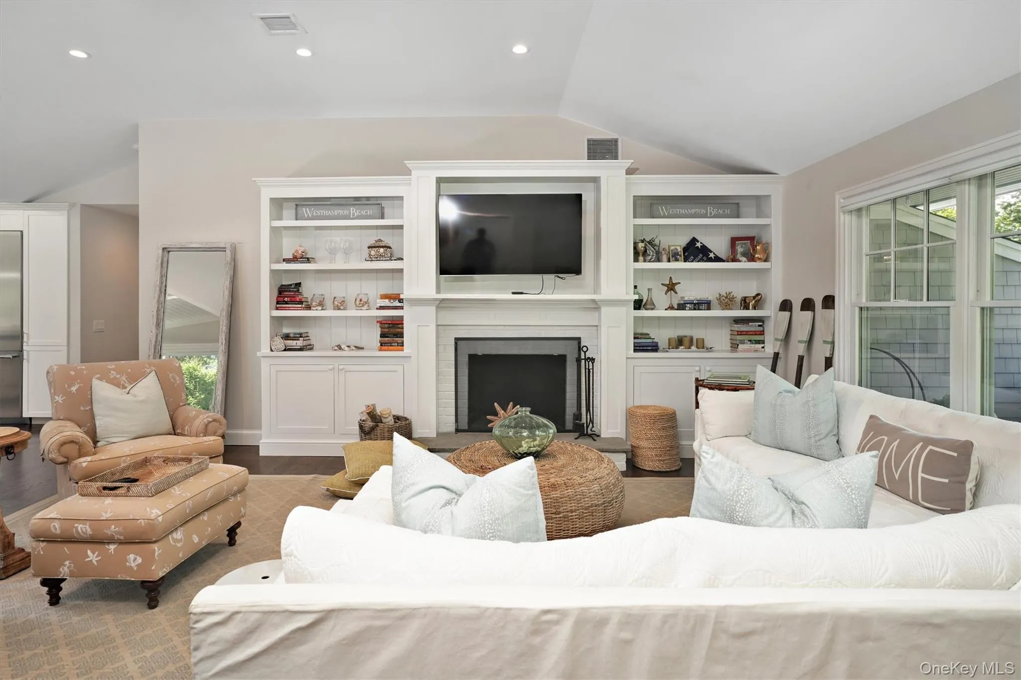 Living area with plenty of natural light, vaulted ceiling, a brick fireplace, wood finished floors, and recessed lighting Living area with plenty of natural light, vaulted ceiling, a brick fireplace, wood finished floors, and recessed lighting