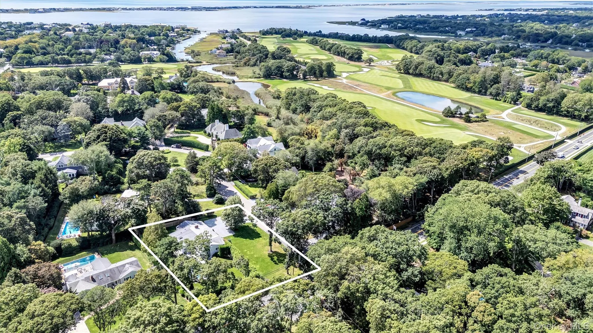 Aerial view of property's location featuring property boundaries highlighted and a large body of water Aerial view of property's location featuring property boundaries highlighted and a large body of water