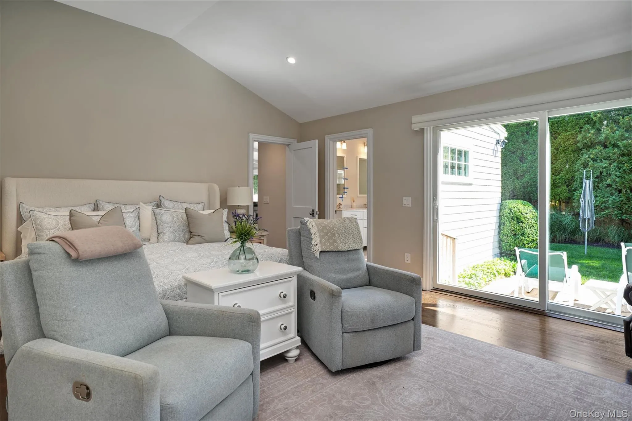 Bedroom with lofted ceiling, access to outside, recessed lighting, wood finished floors, and connected bathroom Bedroom with lofted ceiling, access to outside, recessed lighting, wood finished floors, and connected bathroom