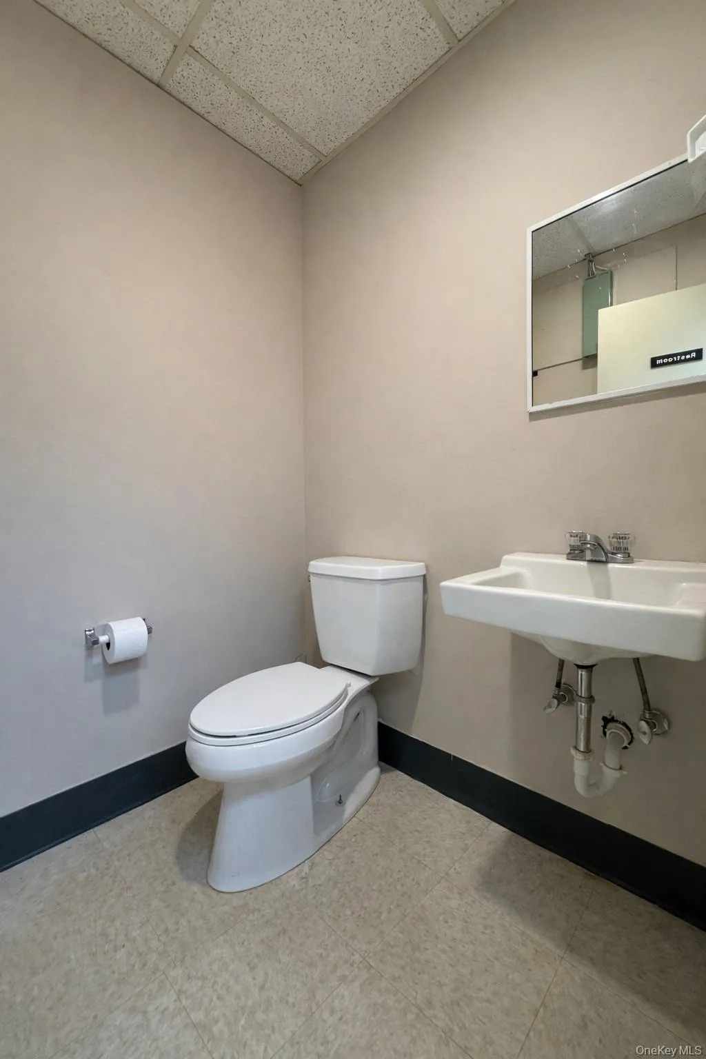 Half bath with baseboards and a drop ceiling Half bath with baseboards and a drop ceiling