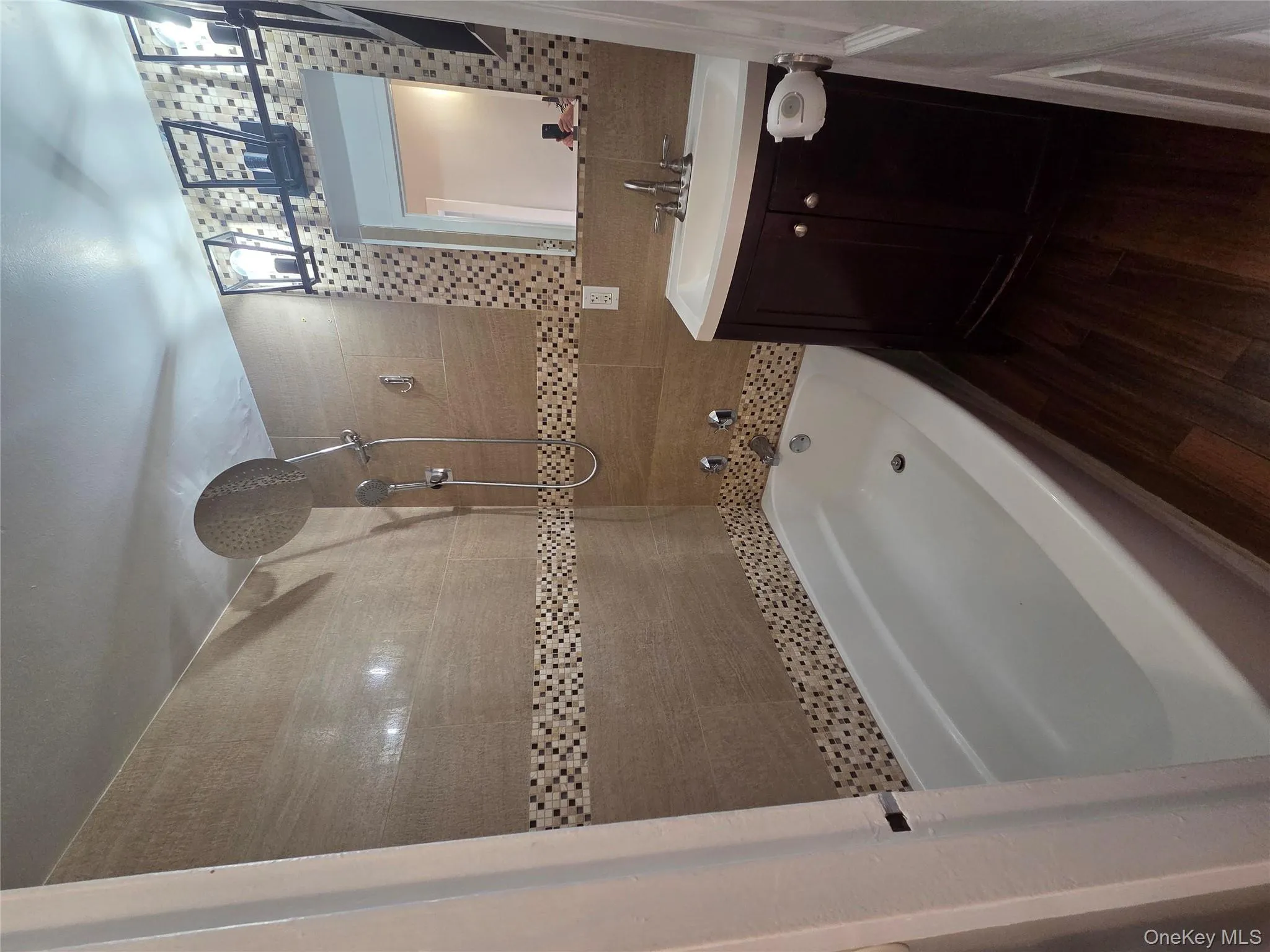Bathroom with shower / washtub combination, dark wood-type flooring, vanity, and tile walls Bathroom with shower / washtub combination, dark wood-type flooring, vanity, and tile walls