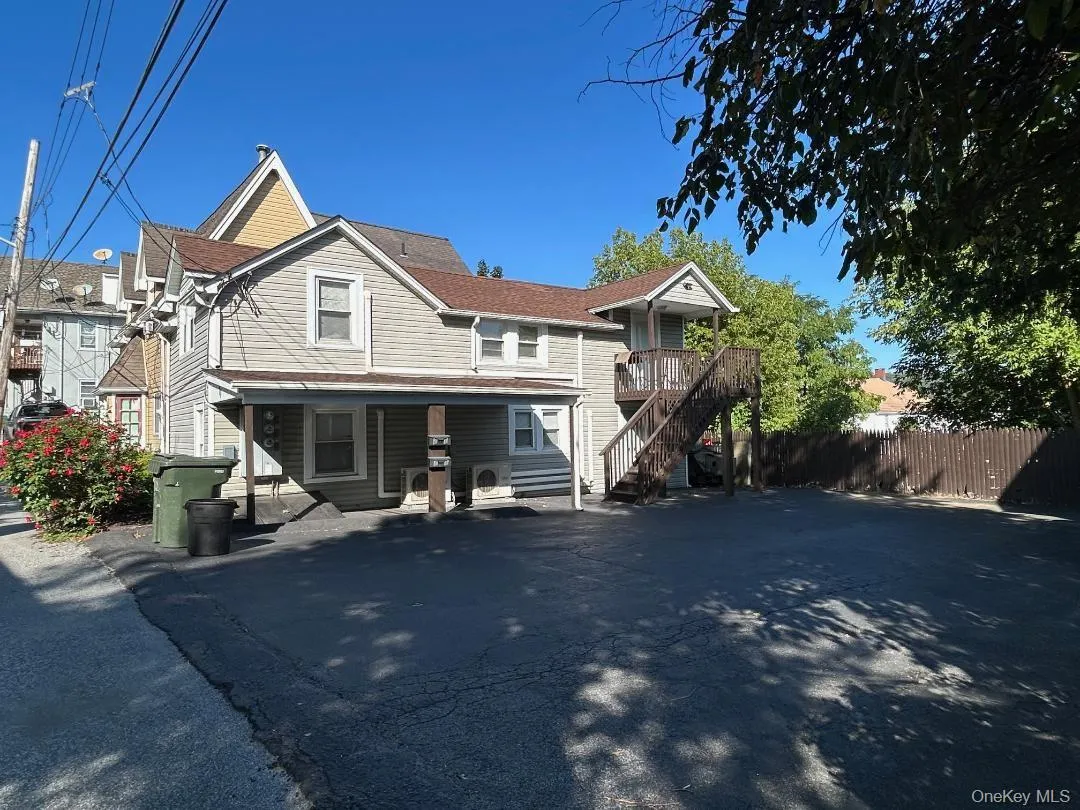 View of front of home with stairway and a wooden deck View of front of home with stairway and a wooden deck