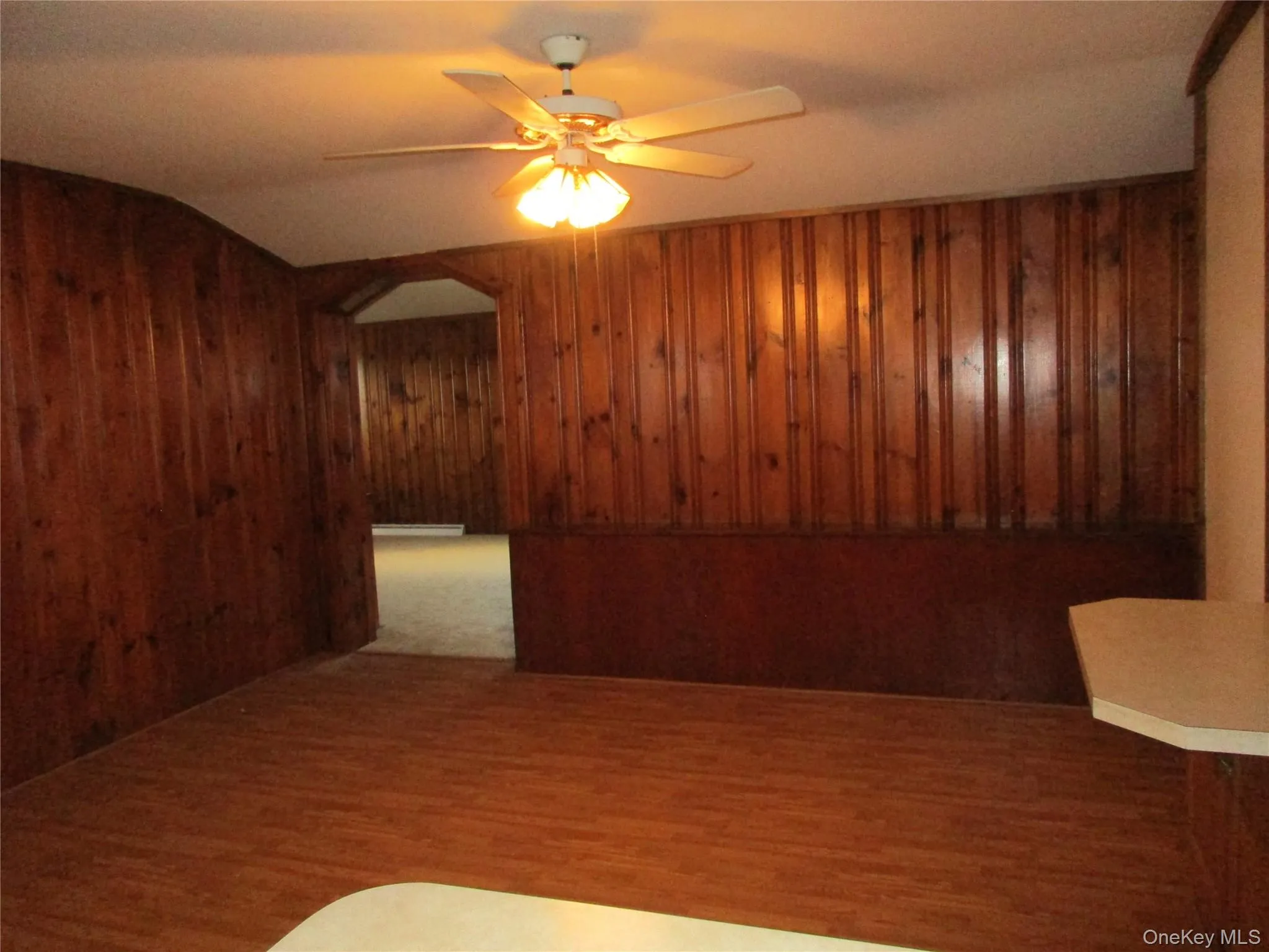 Dining room by kitchen on side - arched walkways, wood finished floors, and ceiling fan Dining room by kitchen on side - arched walkways, wood finished floors, and ceiling fan