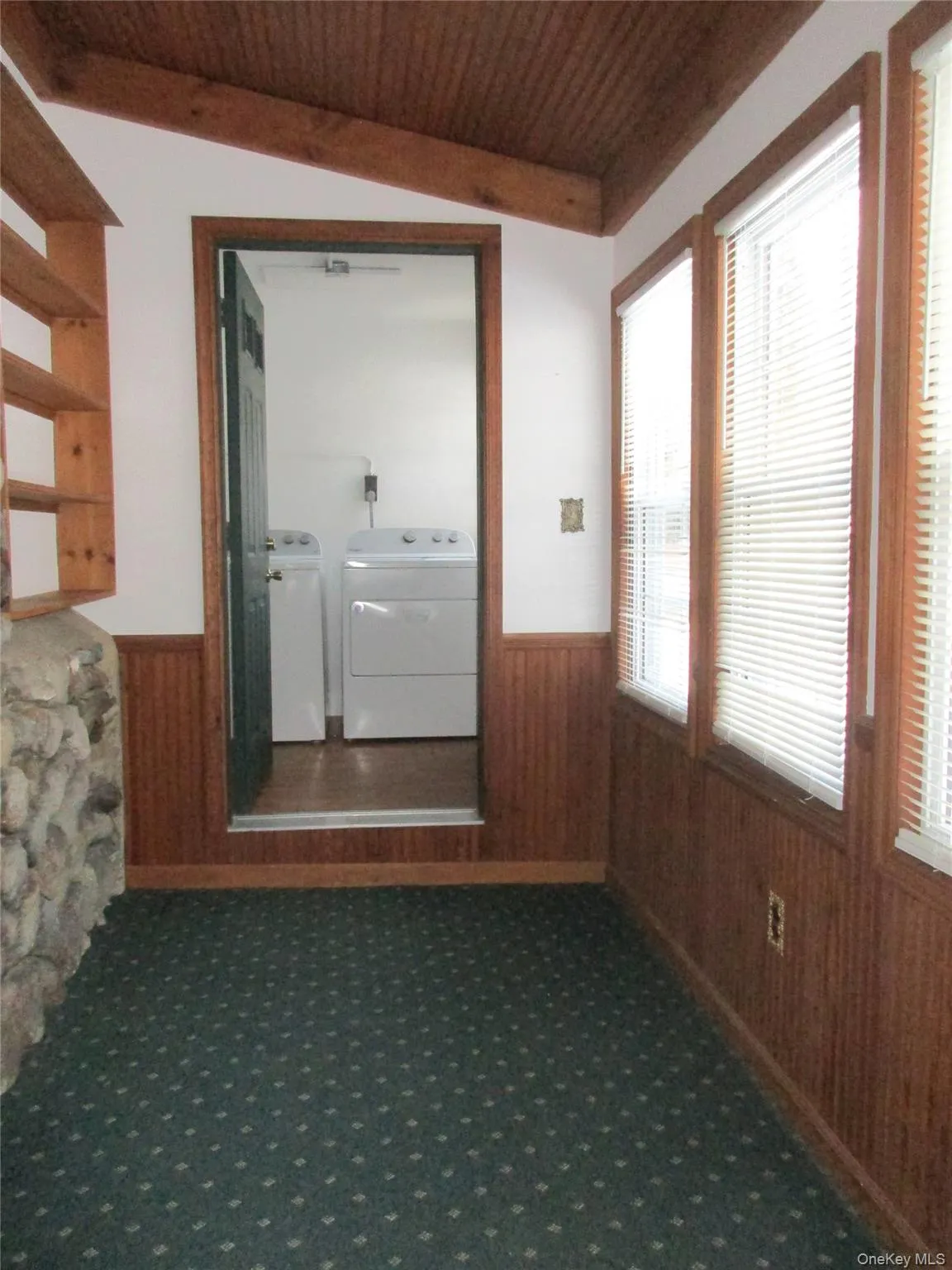 Hallway with wainscoting, carpet flooring, plenty of natural light, wooden walls, and a wooden ceiling Laundry Room on end. Hallway with wainscoting, carpet flooring, plenty of natural light, wooden walls, and a wooden ceiling Laundry Room on end.