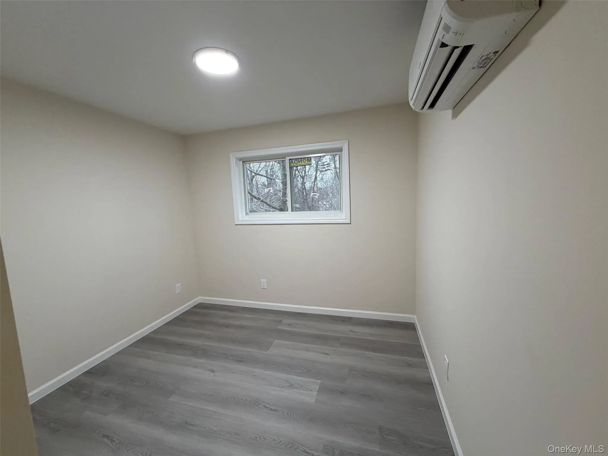 Empty room featuring wood finished floors and a wall unit AC Empty room featuring wood finished floors and a wall unit AC