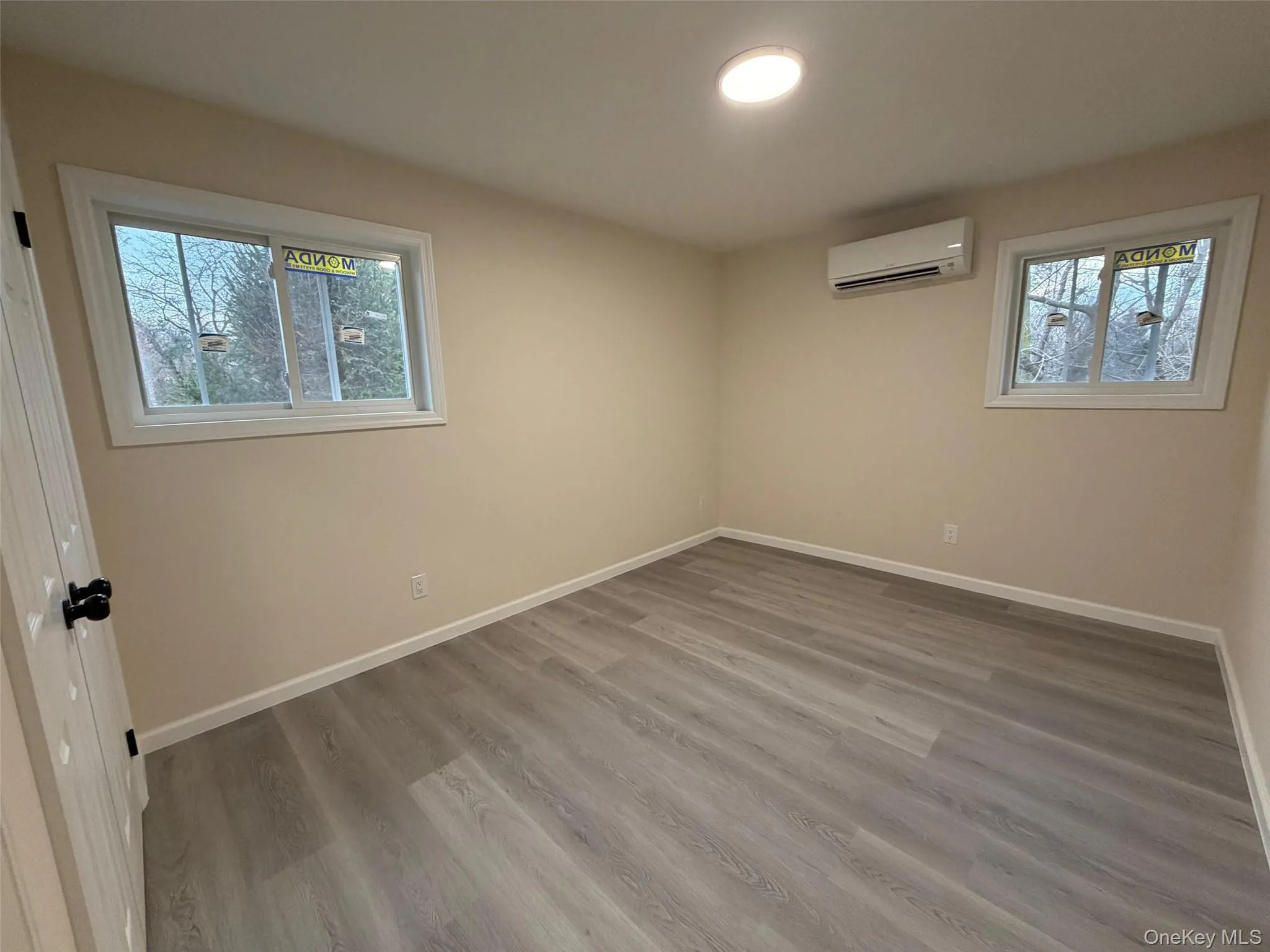 Unfurnished room with light wood-style flooring and a wall unit AC Unfurnished room with light wood-style flooring and a wall unit AC