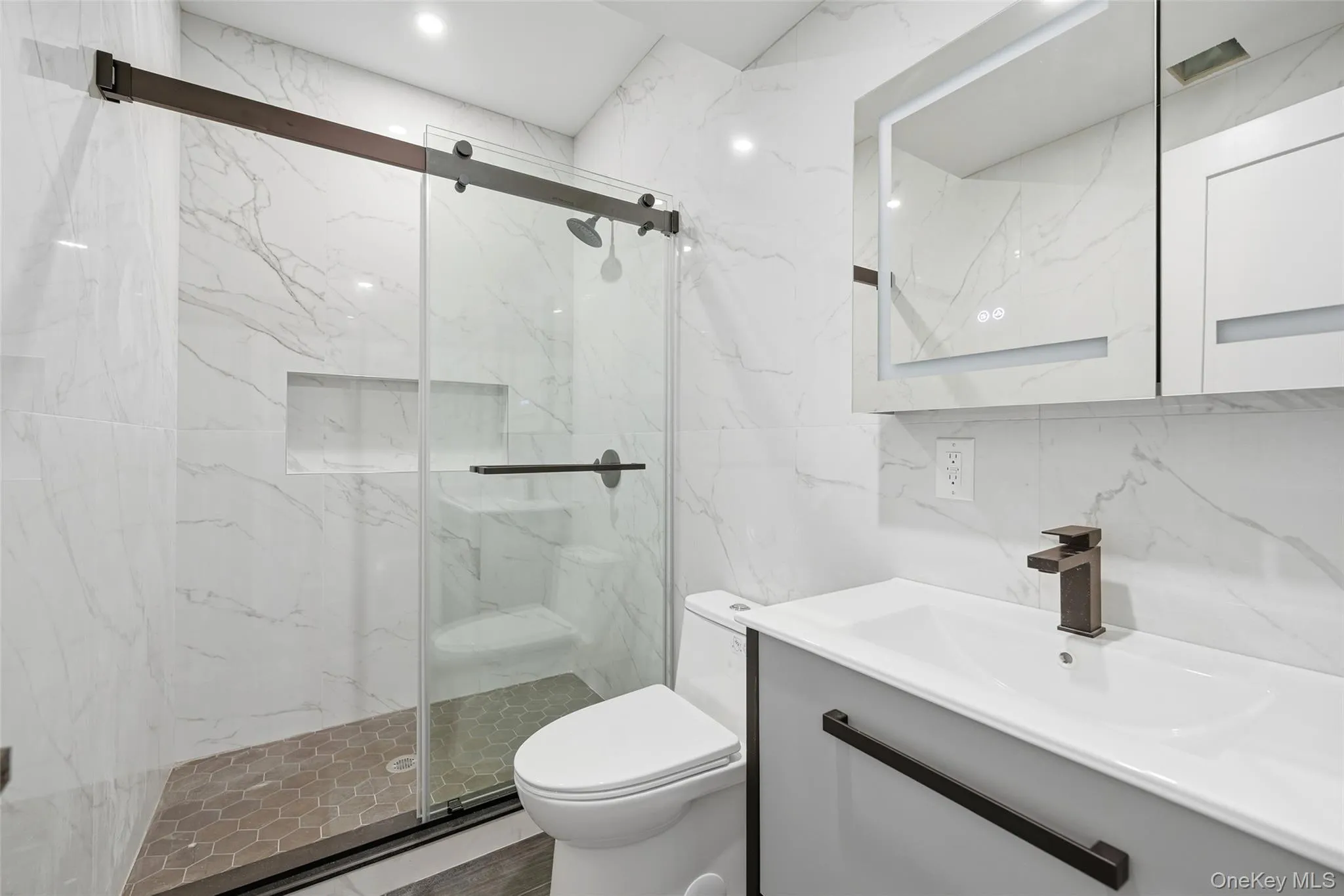 Bathroom with vanity, tile walls, and a marble finish shower Bathroom with vanity, tile walls, and a marble finish shower