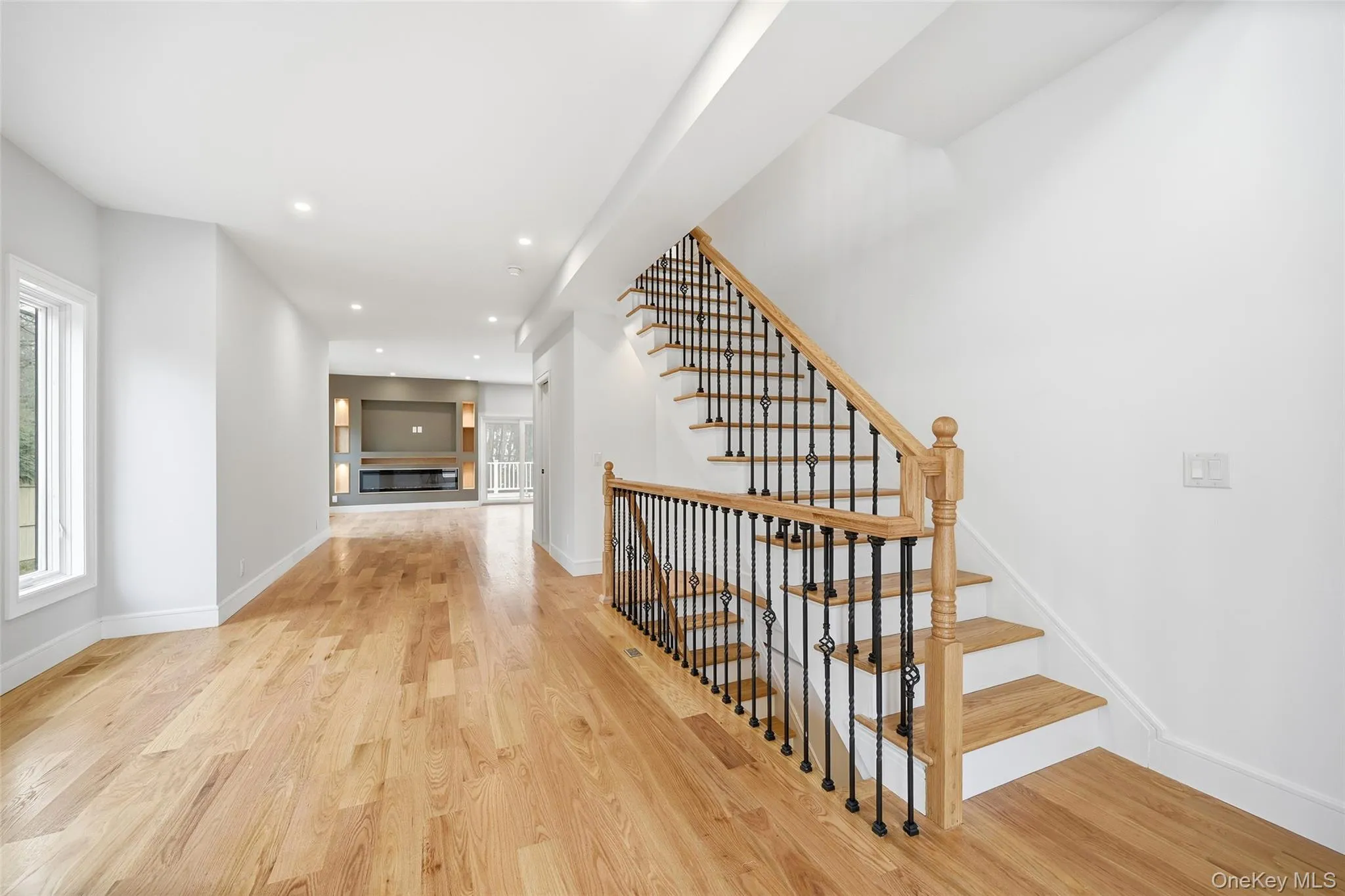 Corridor featuring recessed lighting, light wood-style floors, and stairs Corridor featuring recessed lighting, light wood-style floors, and stairs