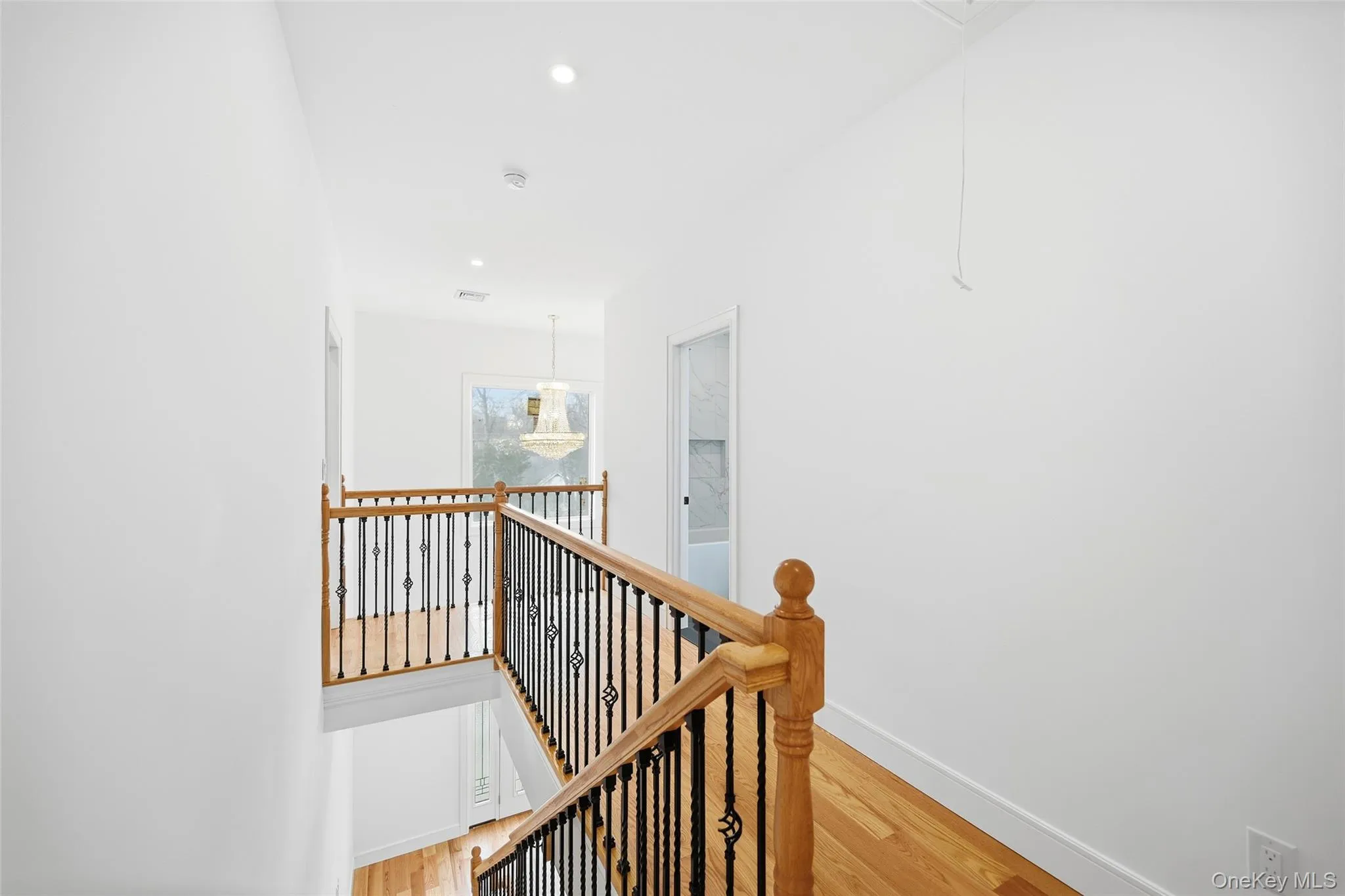Hall featuring an upstairs landing, attic access, light wood-type flooring, and recessed lighting Hall featuring an upstairs landing, attic access, light wood-type flooring, and recessed lighting