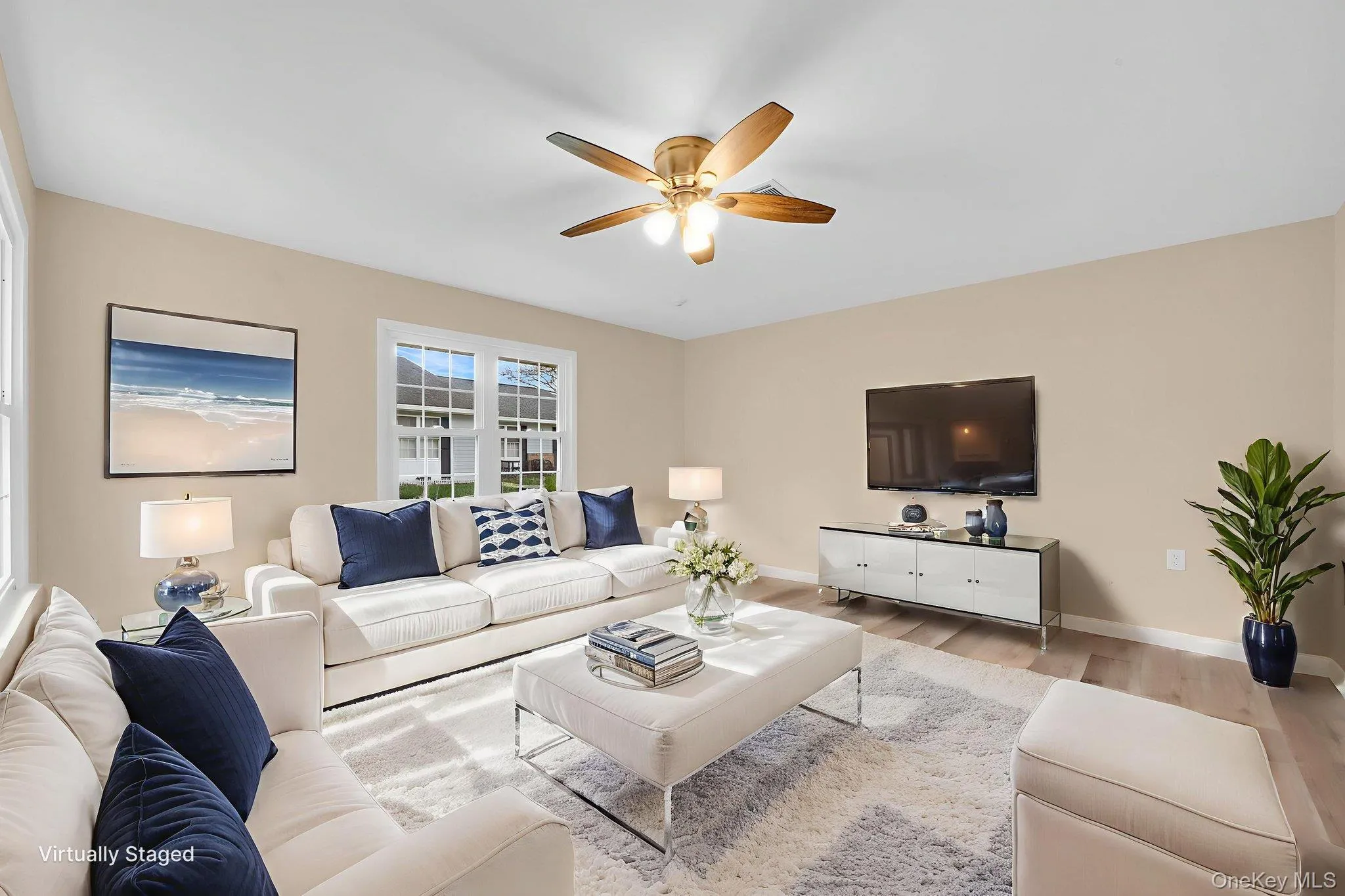 Living room with wood finished floors and a ceiling fan Living room with wood finished floors and a ceiling fan