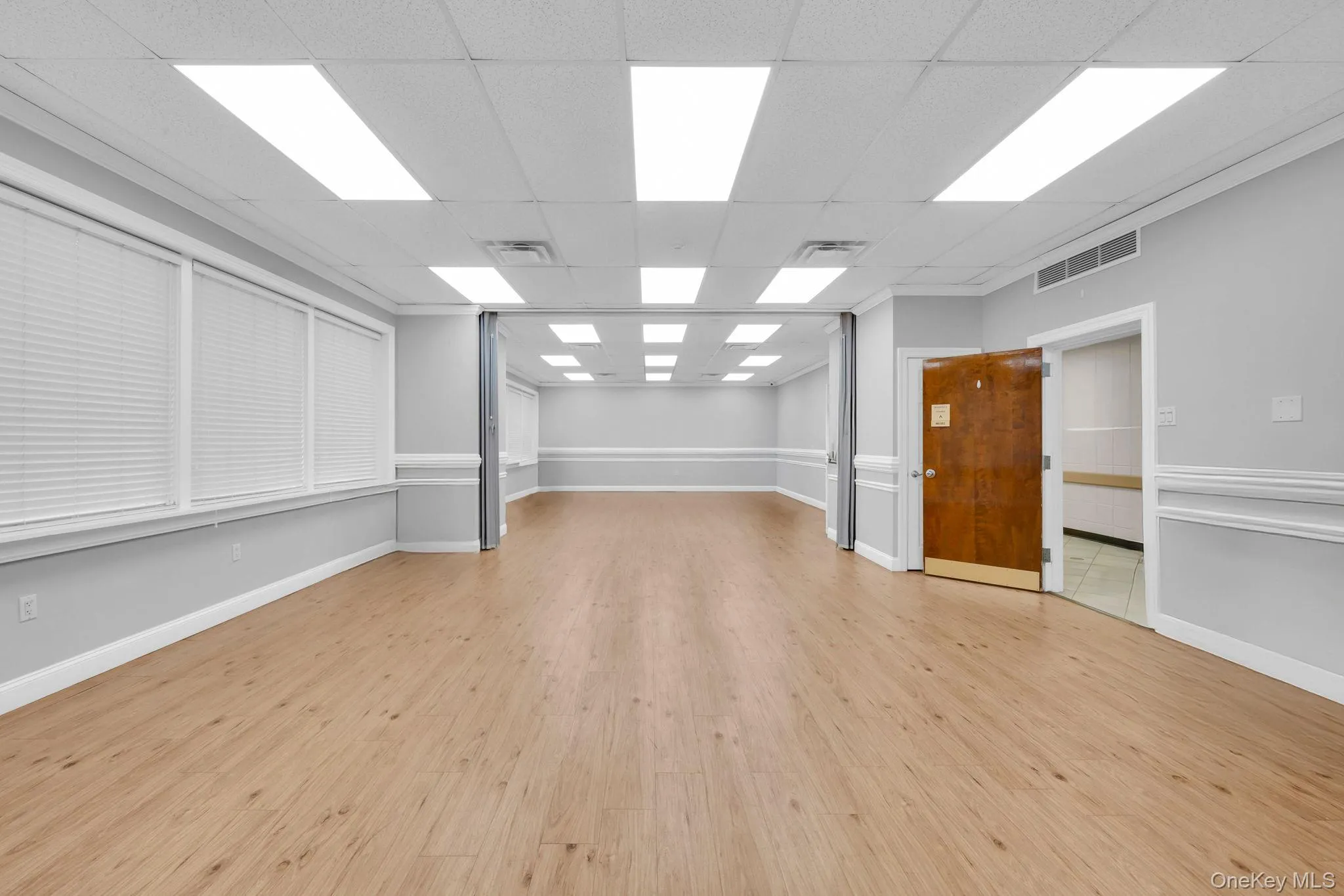 Spare room featuring light wood finished floors and a paneled ceiling Spare room featuring light wood finished floors and a paneled ceiling