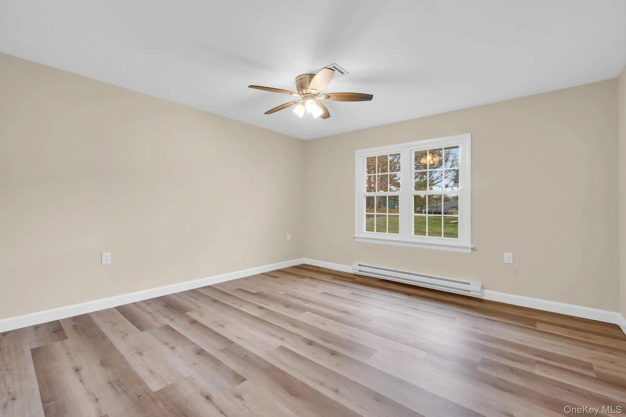 Unfurnished room featuring a baseboard radiator, light wood-style floors, and ceiling fan Unfurnished room featuring a baseboard radiator, light wood-style floors, and ceiling fan