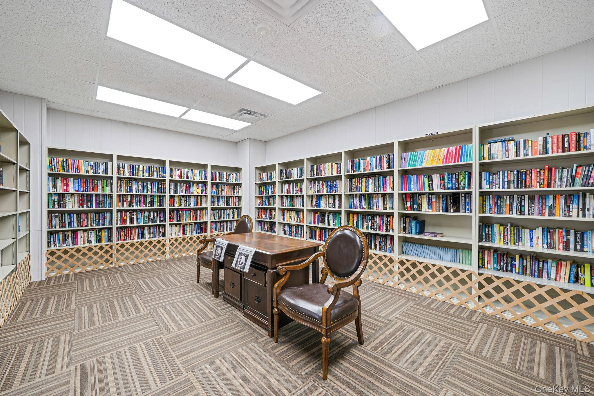 Office area with wall of books and a paneled ceiling Office area with wall of books and a paneled ceiling