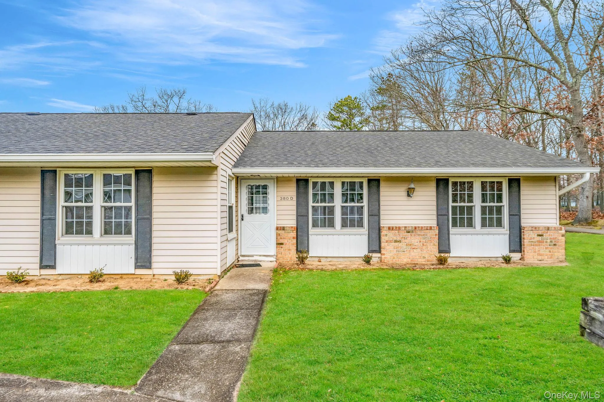 Ranch-style home featuring a front lawn, a shingled roof, and brick siding Ranch-style home featuring a front lawn, a shingled roof, and brick siding
