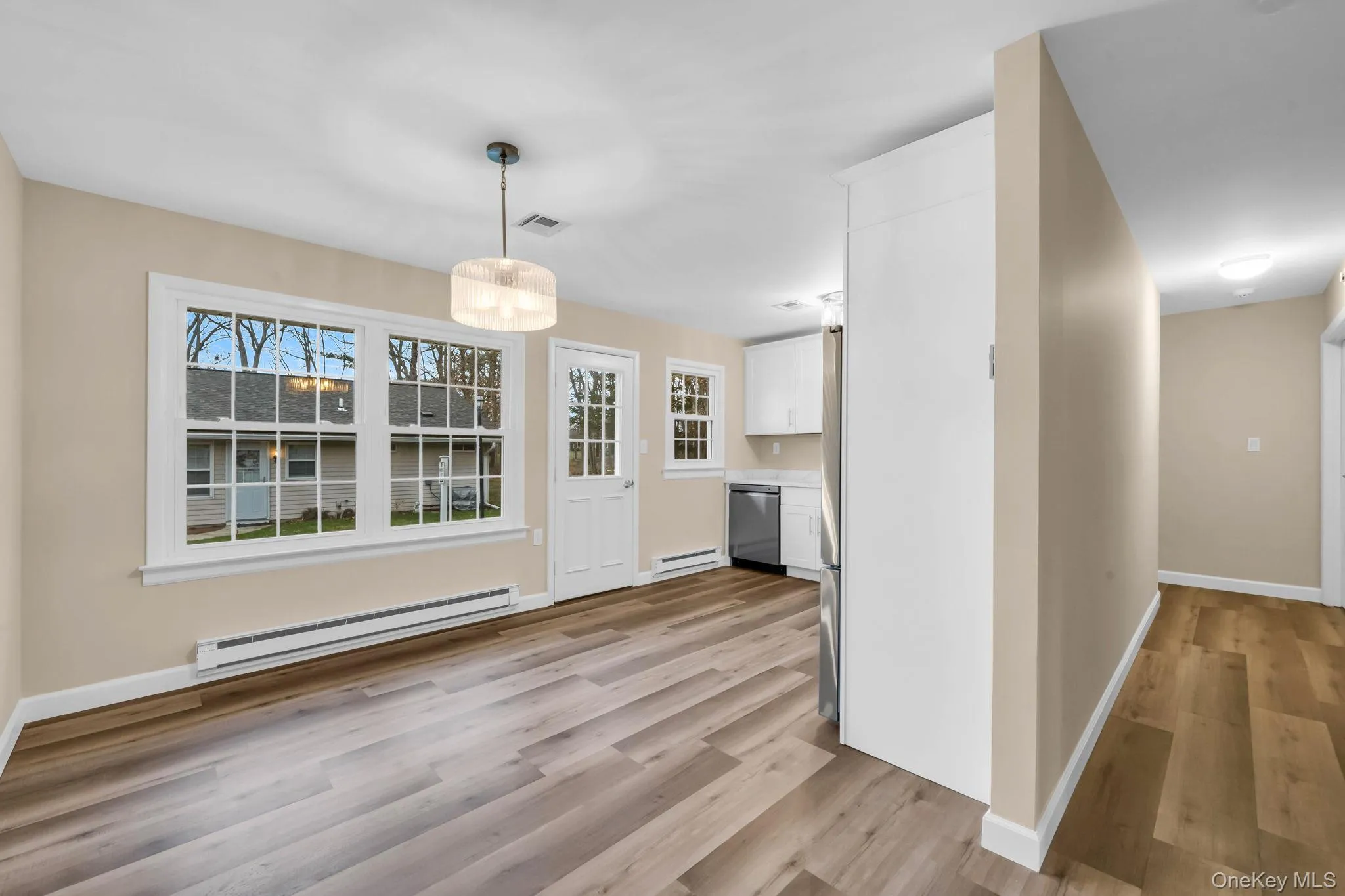 Unfurnished dining area featuring a baseboard radiator and light wood-style flooring Unfurnished dining area featuring a baseboard radiator and light wood-style flooring
