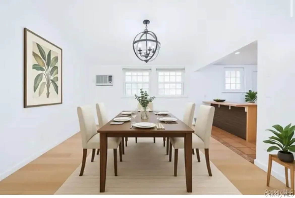 Dining area with light wood-style flooring, plenty of natural light, and a chandelier Dining area with light wood-style flooring, plenty of natural light, and a chandelier