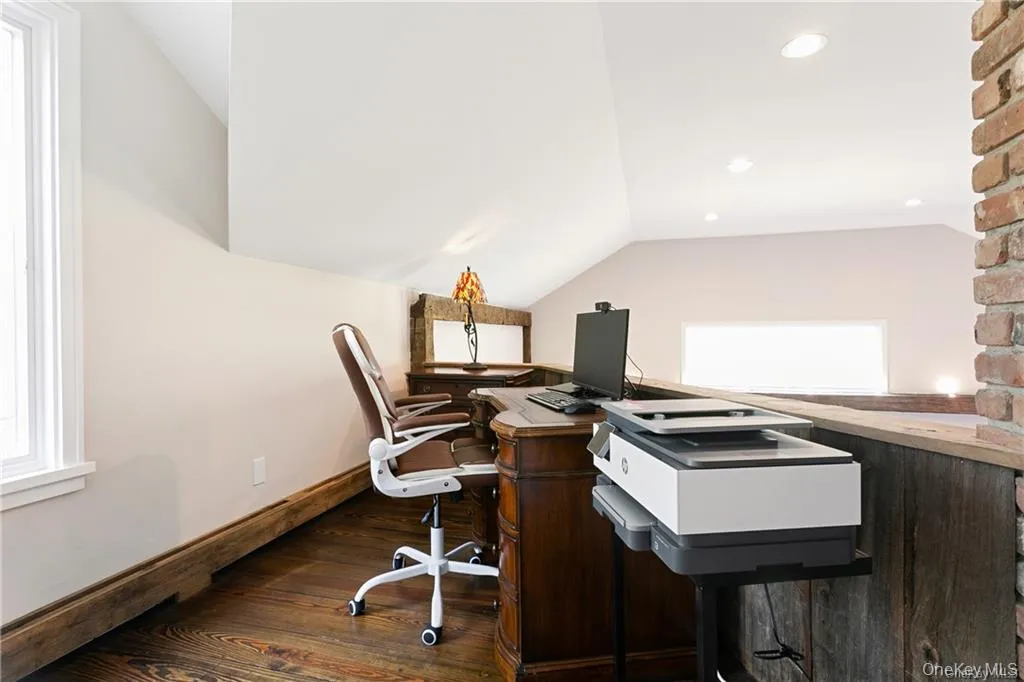 Home office featuring lofted ceiling and dark wood-style flooring Home office featuring lofted ceiling and dark wood-style flooring