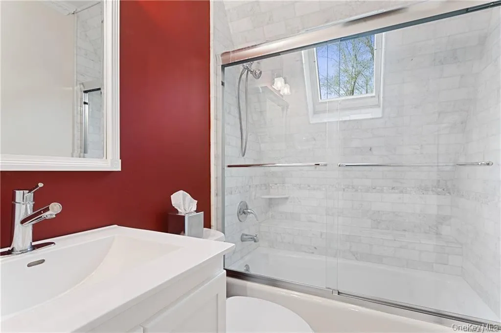 Bathroom featuring vanity and enclosed tub / shower combo Bathroom featuring vanity and enclosed tub / shower combo