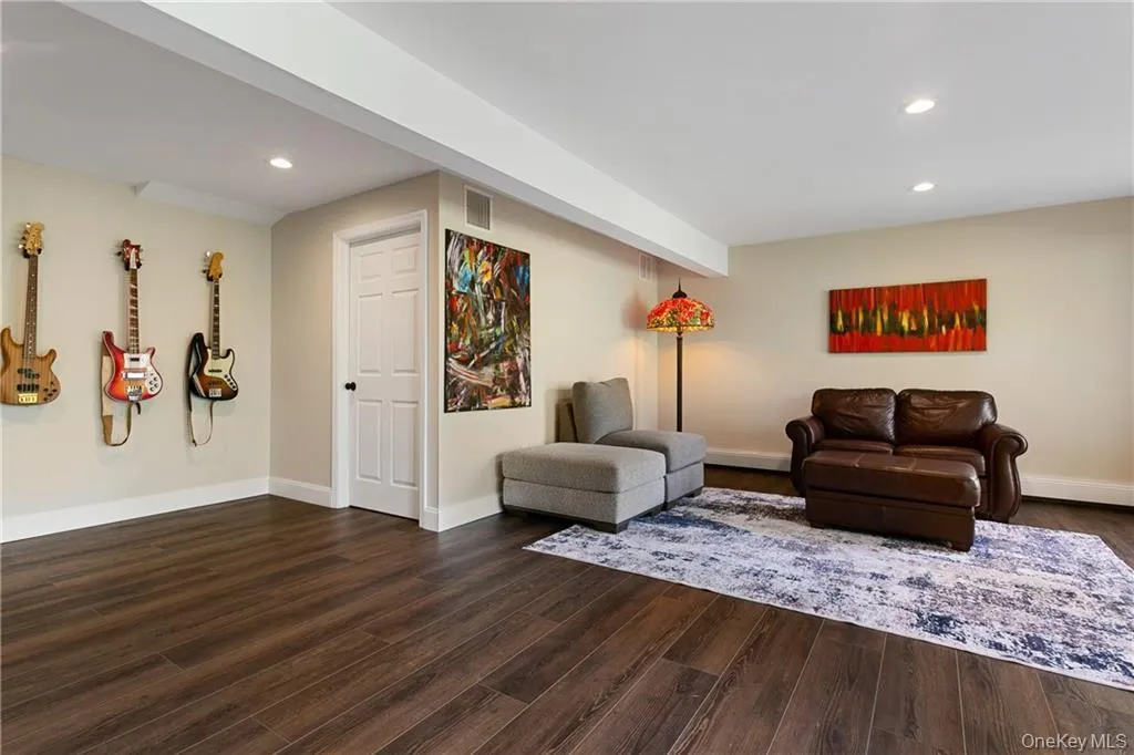 Living area with dark wood-type flooring and recessed lighting Living area with dark wood-type flooring and recessed lighting