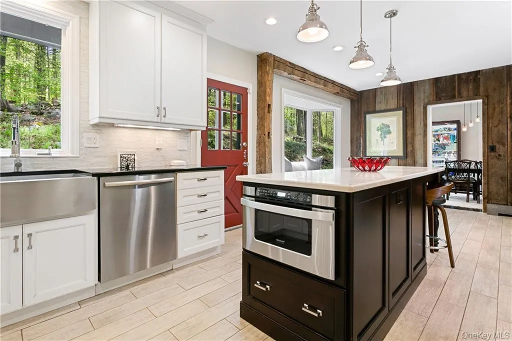 Kitchen with white cabinets, stainless steel appliances, hanging light fixtures, a kitchen island, and recessed lighting Kitchen with white cabinets, stainless steel appliances, hanging light fixtures, a kitchen island, and recessed lighting
