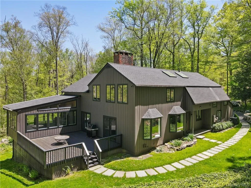 Rear view of property with roof with shingles, a chimney, a lawn, and a wooden deck Rear view of property with roof with shingles, a chimney, a lawn, and a wooden deck