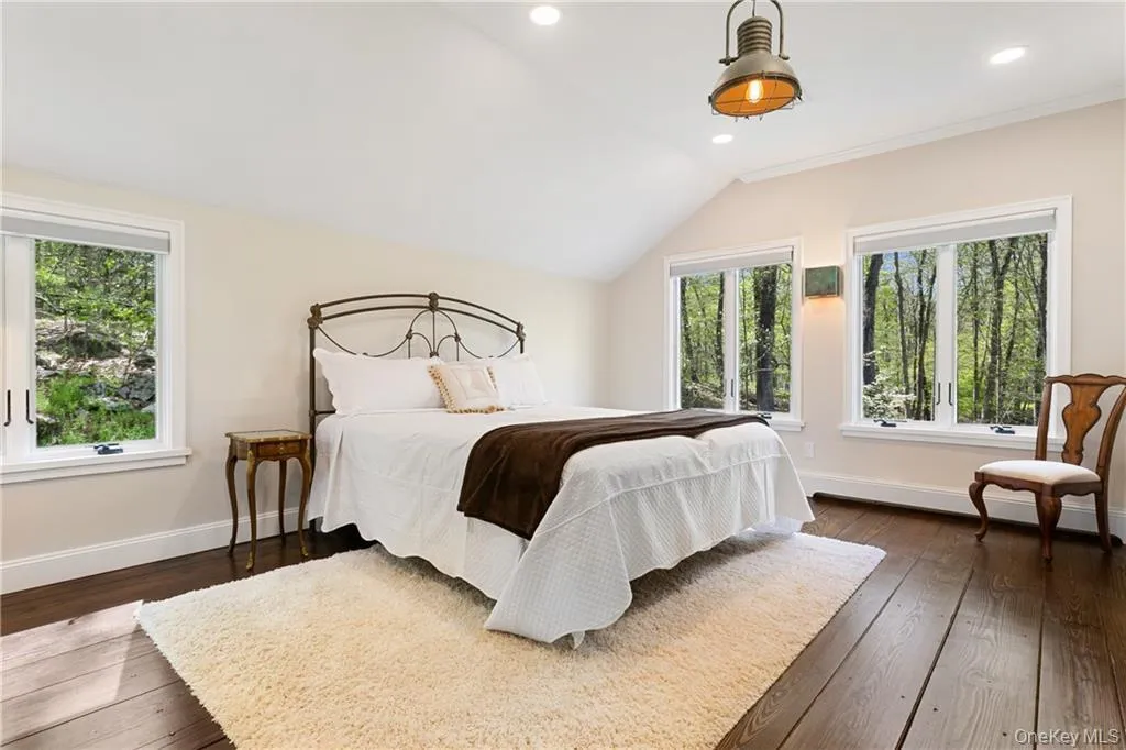 Bedroom with lofted ceiling, dark wood-style floors, and recessed lighting Bedroom with lofted ceiling, dark wood-style floors, and recessed lighting