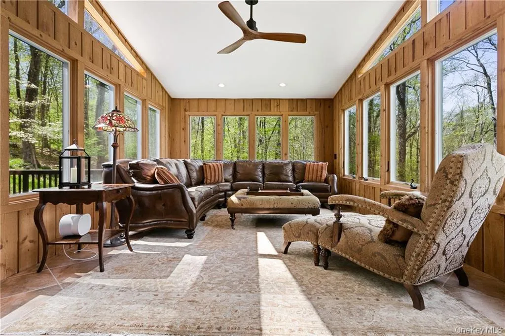 Sunroom featuring wood walls, vaulted ceiling, and recessed lighting Sunroom featuring wood walls, vaulted ceiling, and recessed lighting