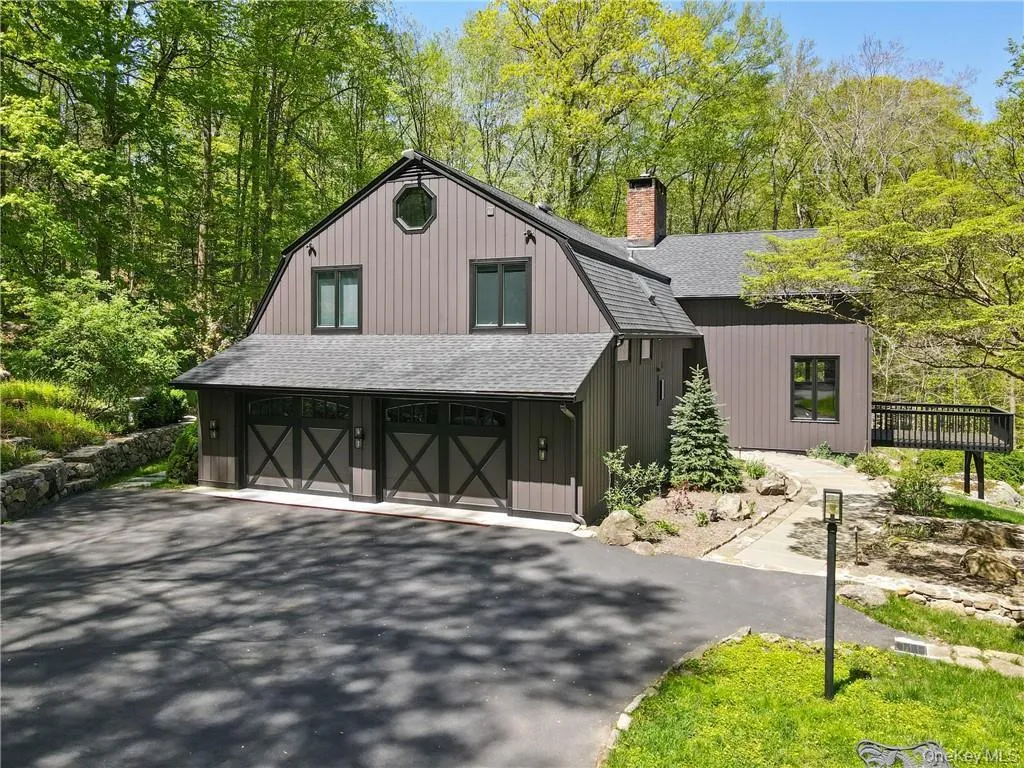 View of front of home featuring a shingled roof, a gambrel roof, asphalt driveway, a garage, and a chimney View of front of home featuring a shingled roof, a gambrel roof, asphalt driveway, a garage, and a chimney