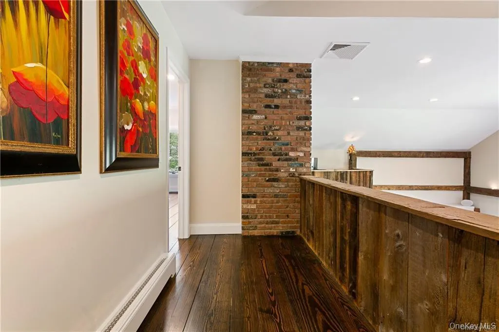 Corridor featuring baseboard heating, dark wood finished floors, and recessed lighting Corridor featuring baseboard heating, dark wood finished floors, and recessed lighting