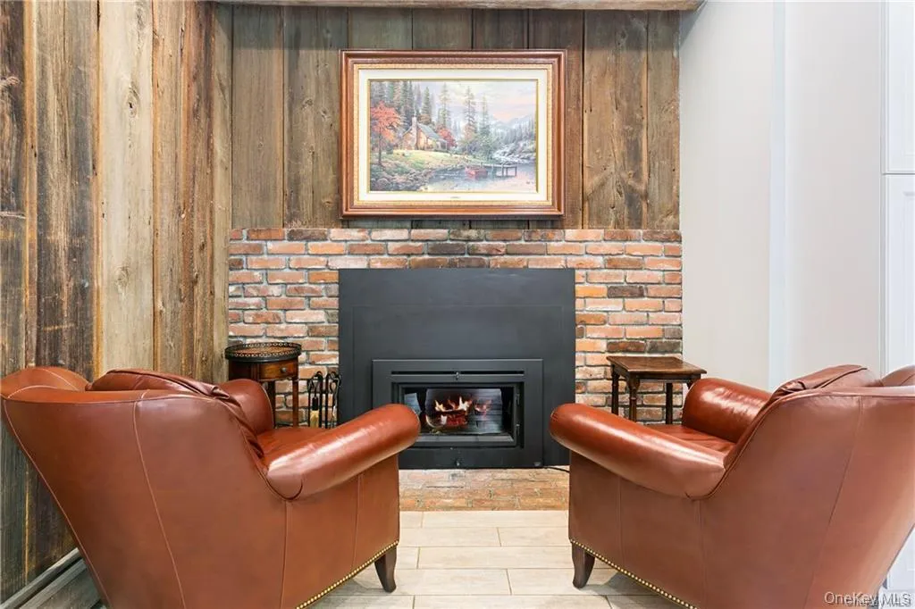 Sitting room featuring a fireplace and wood walls Sitting room featuring a fireplace and wood walls