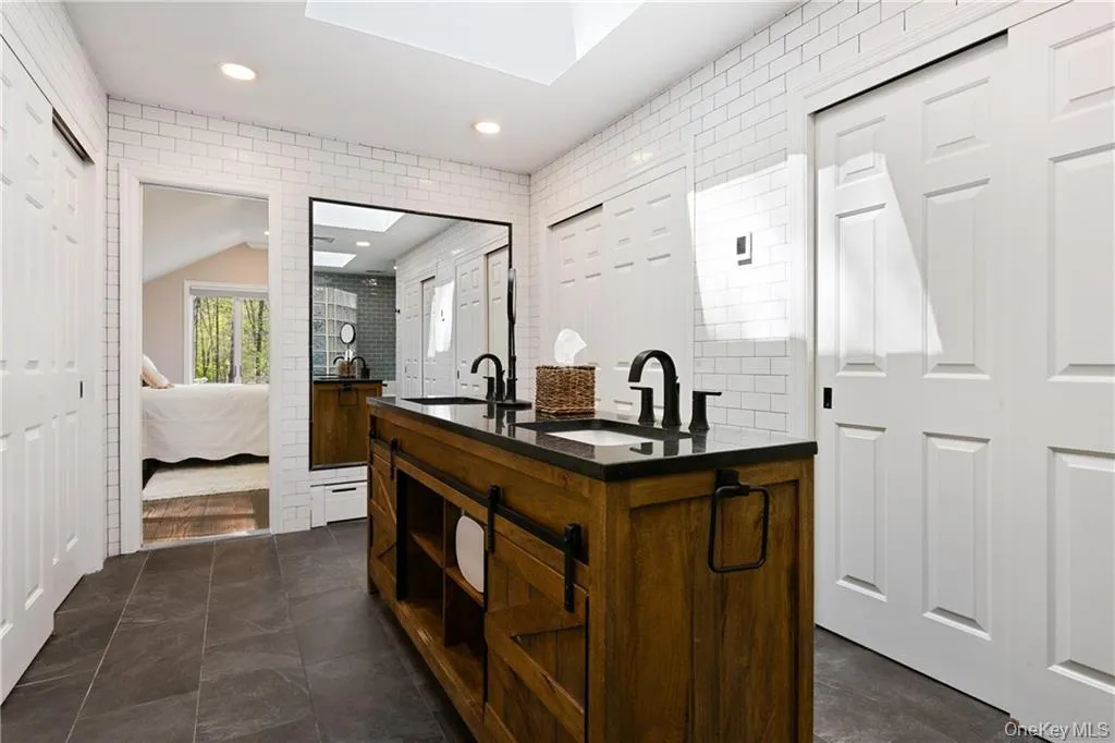Bar area with a skylight, dark stone countertops, recessed lighting, lofted ceiling, and open shelves Bar area with a skylight, dark stone countertops, recessed lighting, lofted ceiling, and open shelves