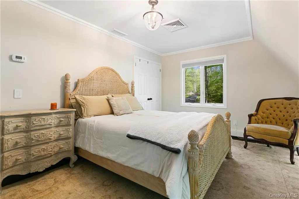 Bedroom with crown molding, carpet floors, and a closet Bedroom with crown molding, carpet floors, and a closet