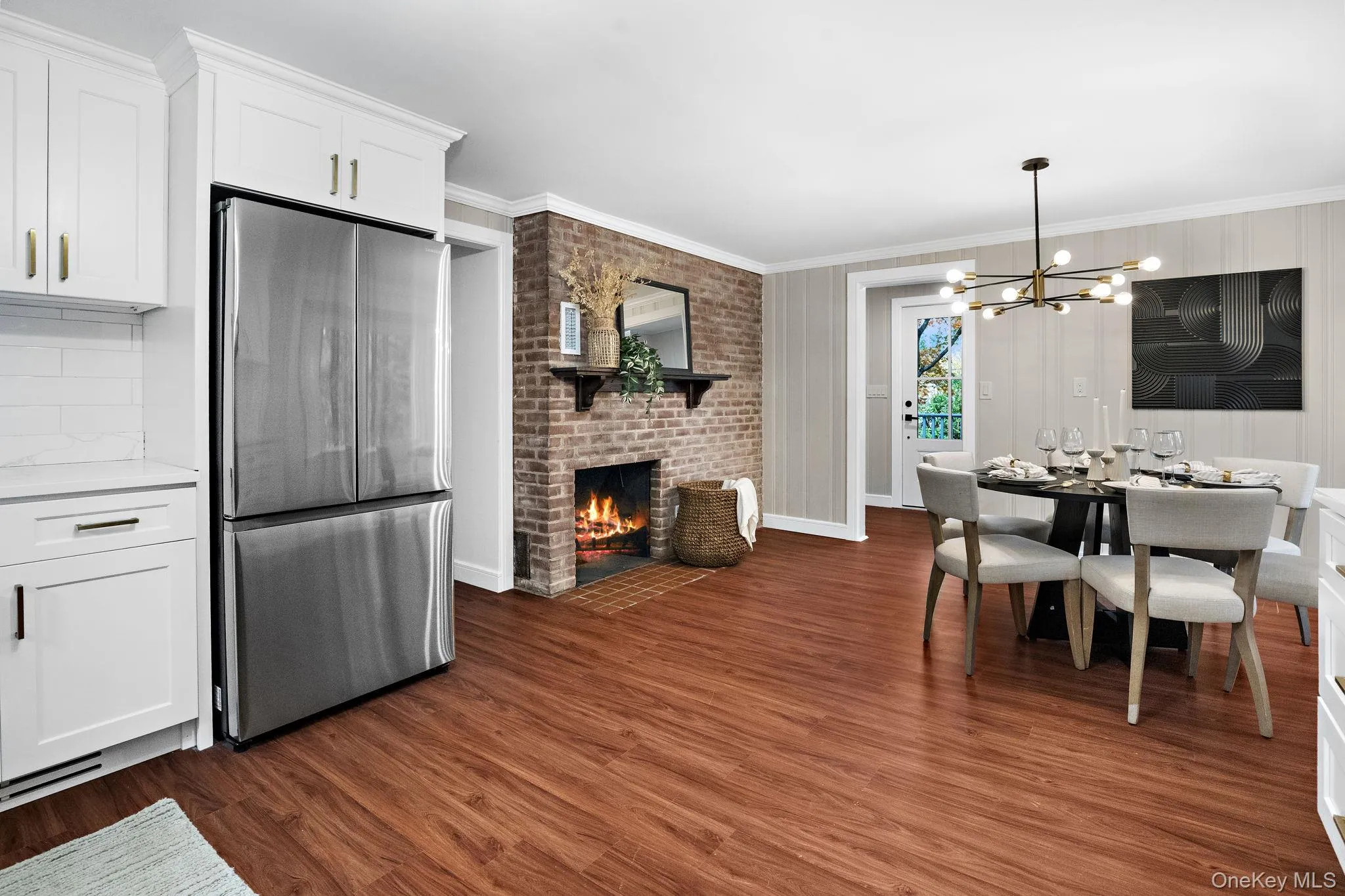 The heart of the home — this open kitchen and dining area blend modern design with a touch of classic warmth, anchored by a second brick fireplace. The heart of the home — this open kitchen and dining area blend modern design with a touch of classic warmth, anchored by a second brick fireplace.