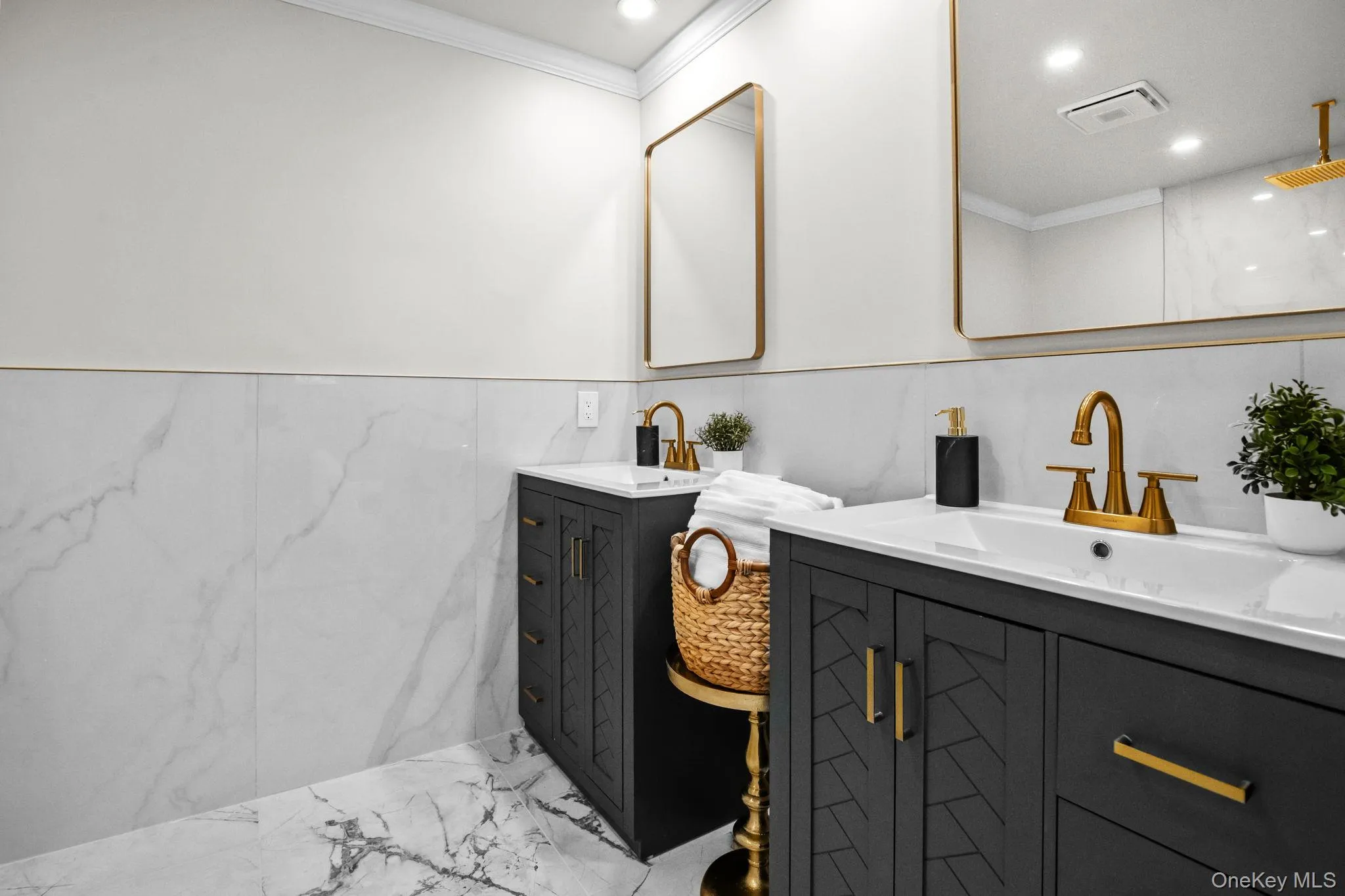 Dual vanities with quartz counters, gold fixtures, and modern mirrors create a sleek and luxurious setting. Dual vanities with quartz counters, gold fixtures, and modern mirrors create a sleek and luxurious setting.