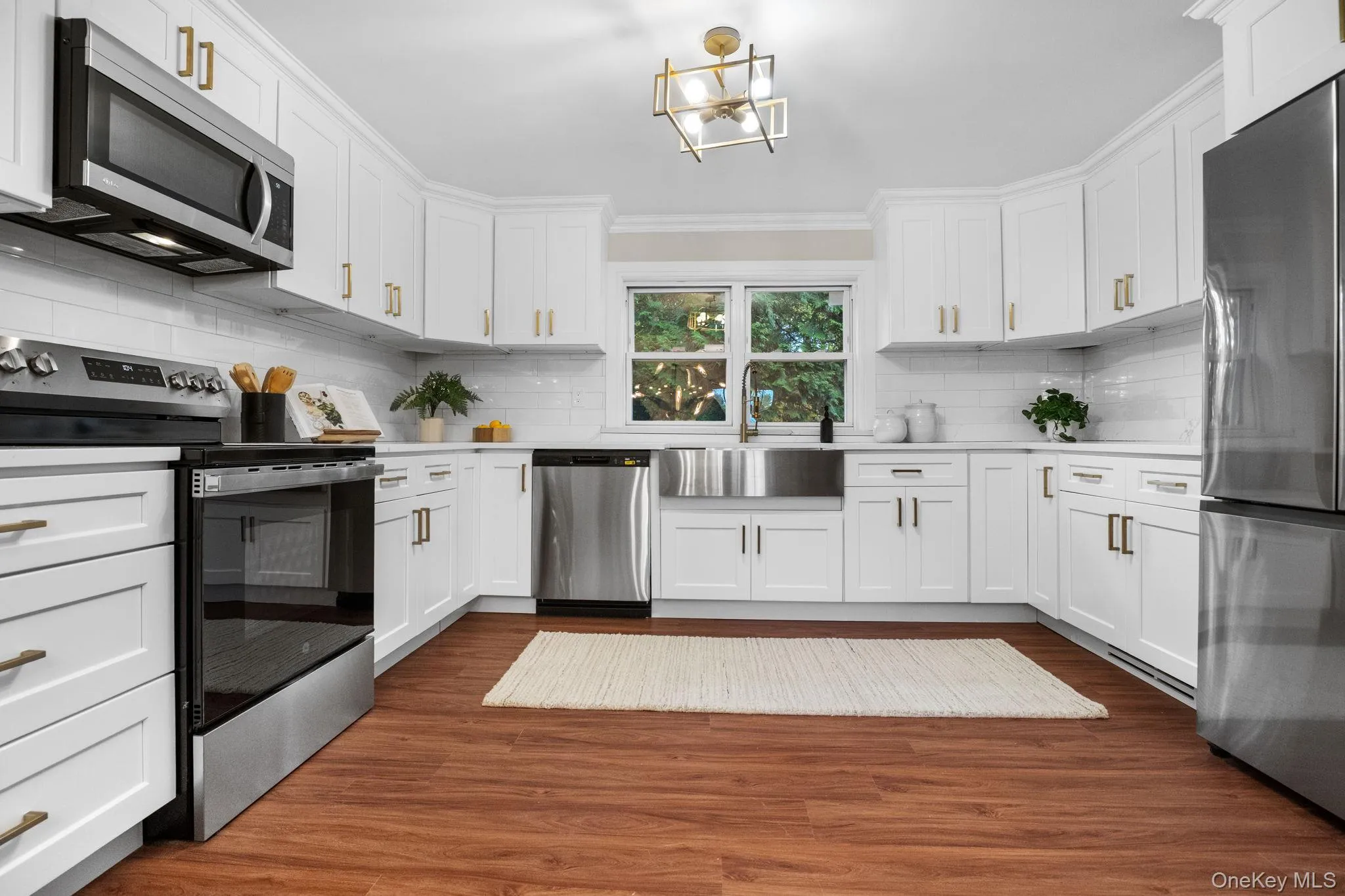 Bright and spacious kitchen with custom shaker cabinets, gold hardware, and a farmhouse sink for a perfect blend of elegance and function. Bright and spacious kitchen with custom shaker cabinets, gold hardware, and a farmhouse sink for a perfect blend of elegance and function.