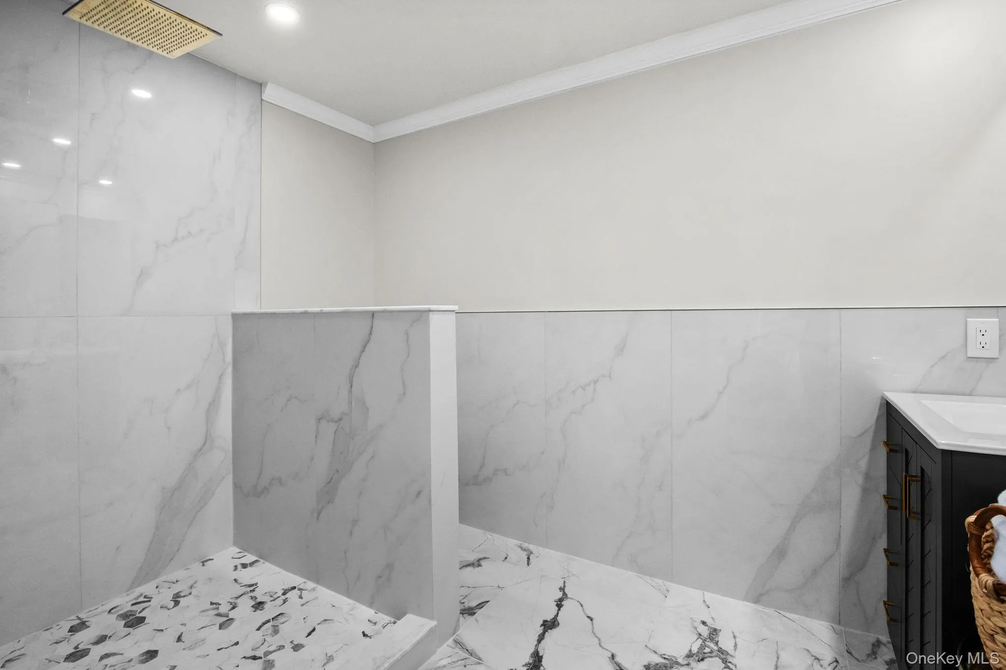 Walk-in shower with marble-style tile, frameless half wall, and rainfall showerhead for a spa-inspired experience. Walk-in shower with marble-style tile, frameless half wall, and rainfall showerhead for a spa-inspired experience.
