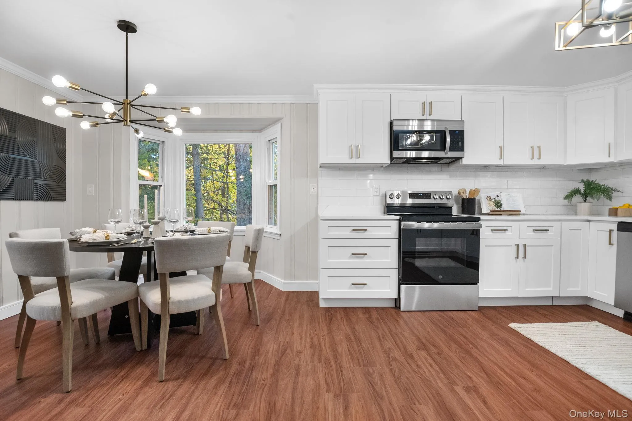 Newly renovated kitchen and dining area featuring quartz counters, stainless steel appliances, and a bay window that fills the space with natural light. Newly renovated kitchen and dining area featuring quartz counters, stainless steel appliances, and a bay window that fills the space with natural light.