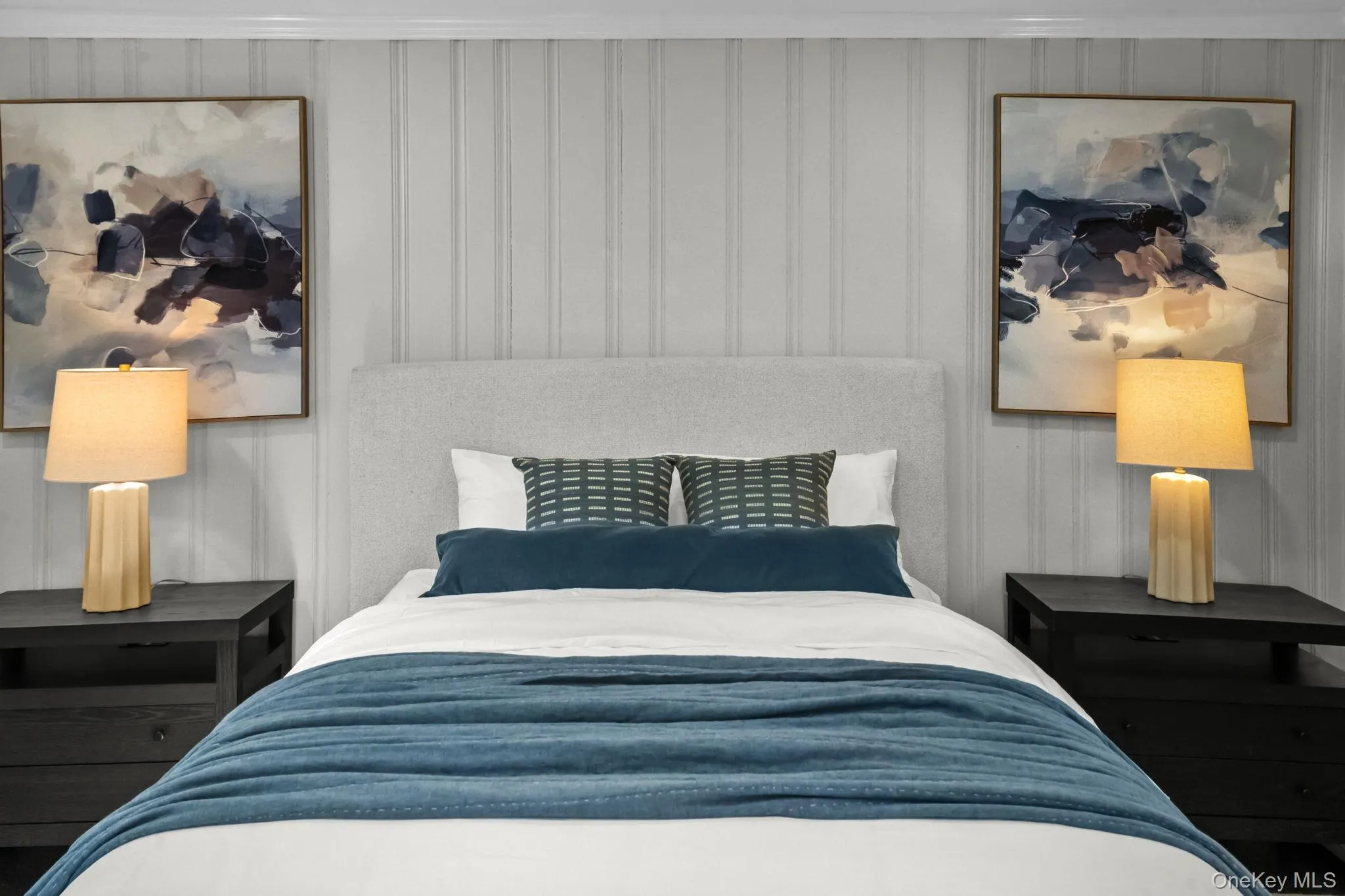 Custom wall paneling and updated lighting elevate the style and warmth of this beautifully finished bedroom. Custom wall paneling and updated lighting elevate the style and warmth of this beautifully finished bedroom.