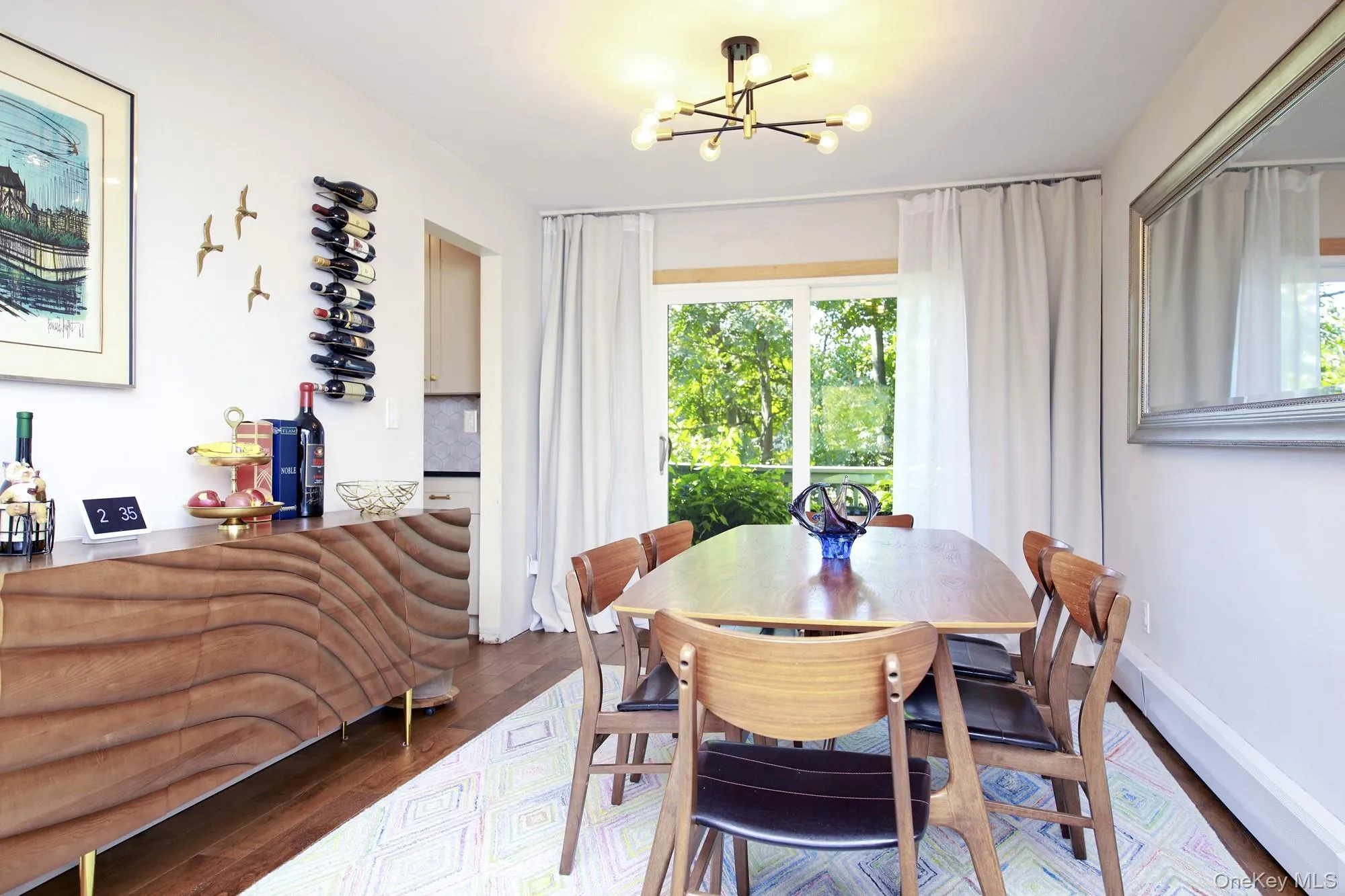Dining area with wood finished floors, a chandelier, and baseboard heating Dining area with wood finished floors, a chandelier, and baseboard heating
