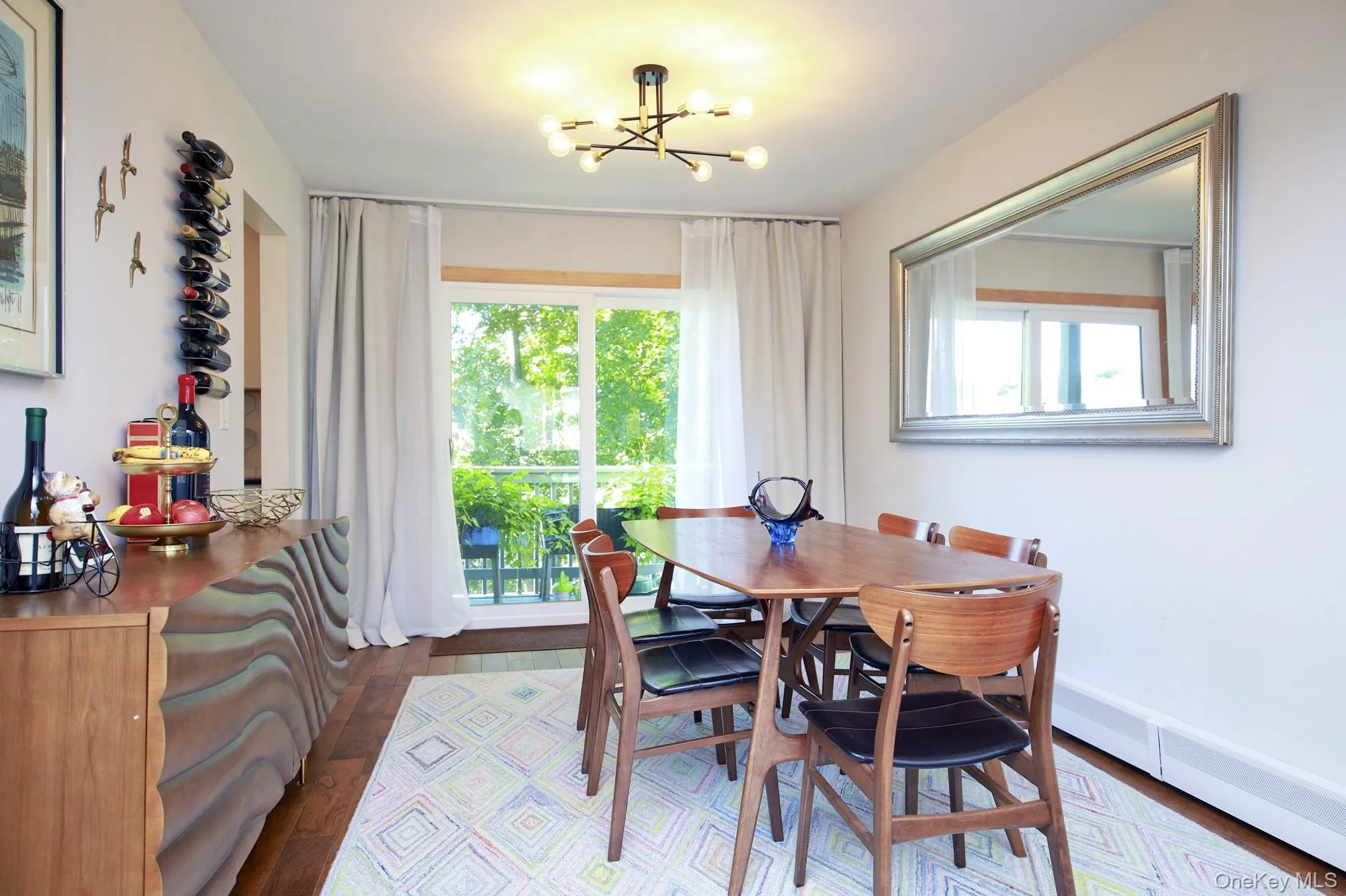 Dining area with dark wood-style floors, plenty of natural light, and a chandelier Dining area with dark wood-style floors, plenty of natural light, and a chandelier