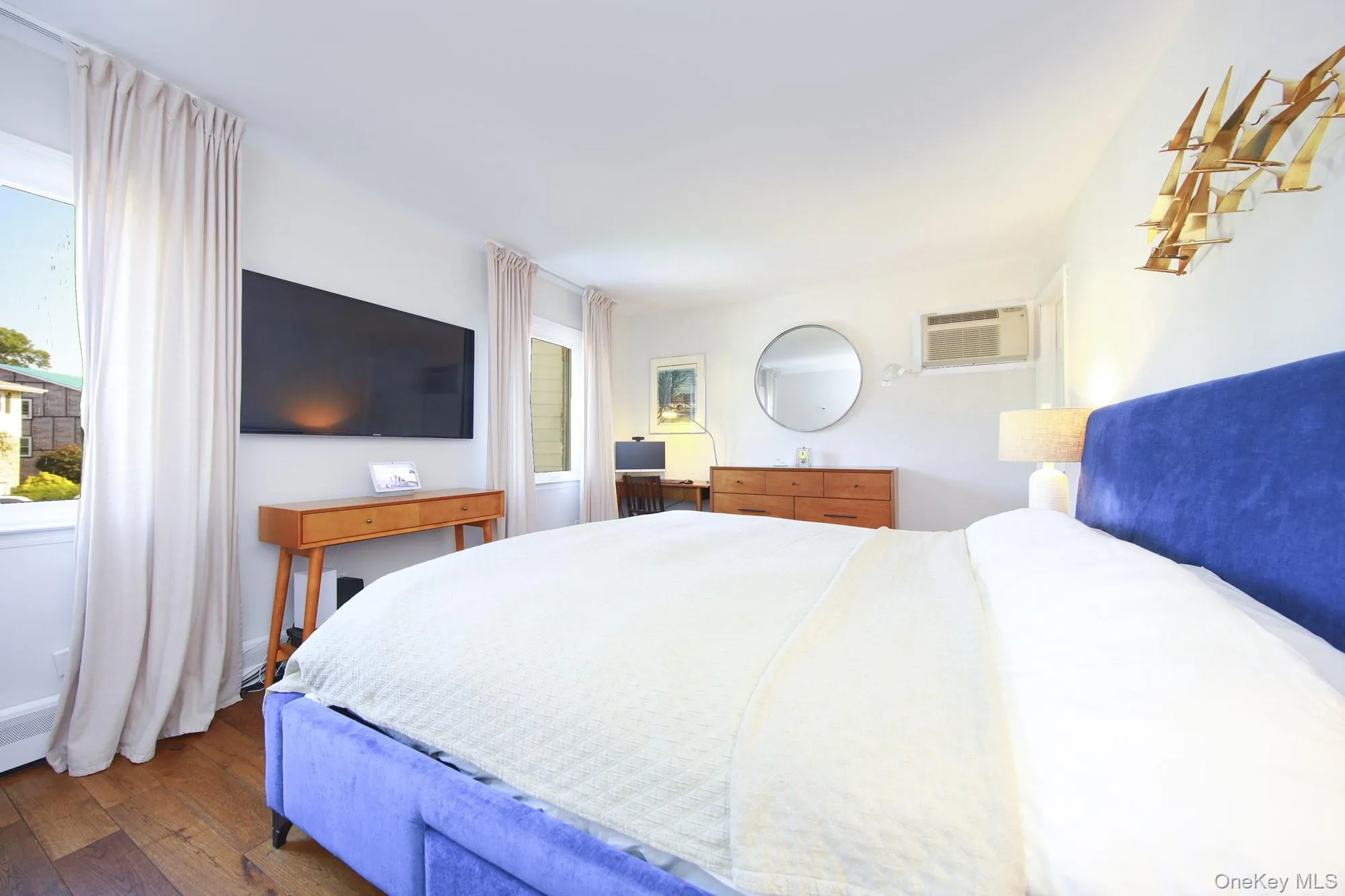 Bedroom featuring hardwood / wood-style floors and a wall mounted AC Bedroom featuring hardwood / wood-style floors and a wall mounted AC