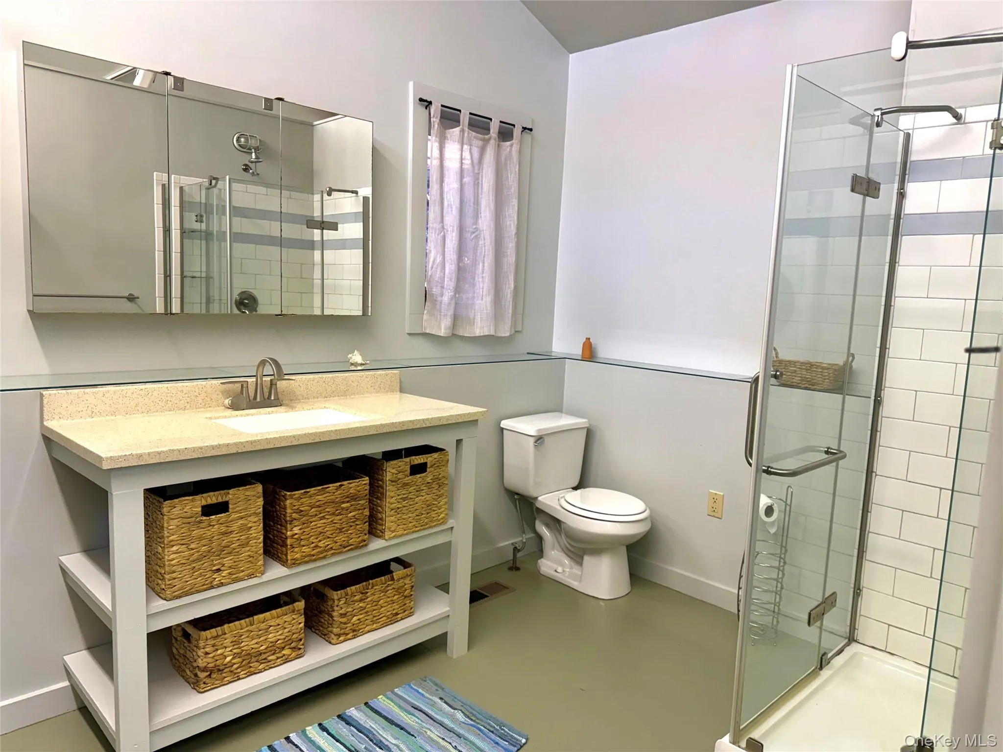 Full bathroom featuring a stall shower, finished concrete flooring, and vanity Full bathroom featuring a stall shower, finished concrete flooring, and vanity